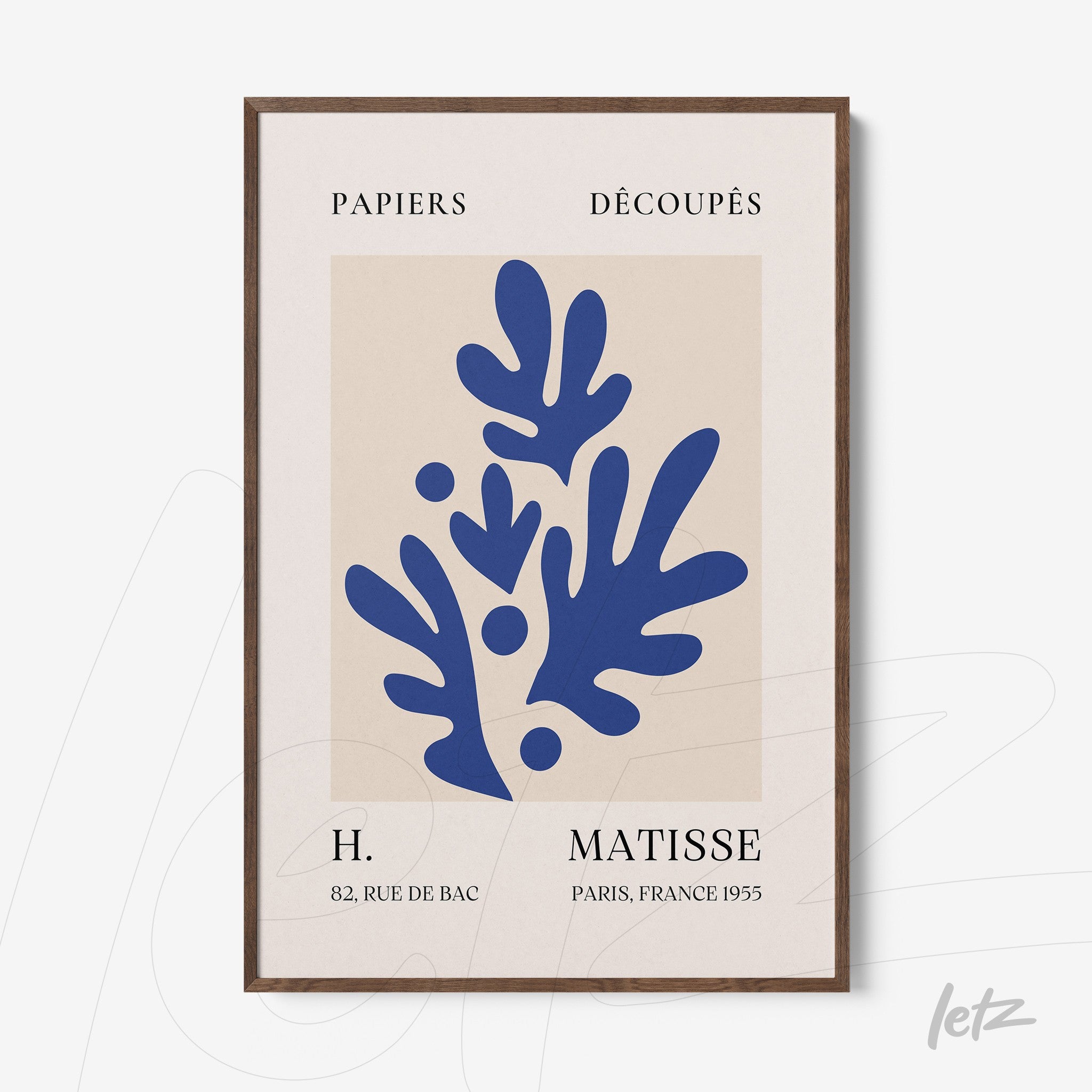 framed art of paper cutouts in blue on light background with dark wood frame