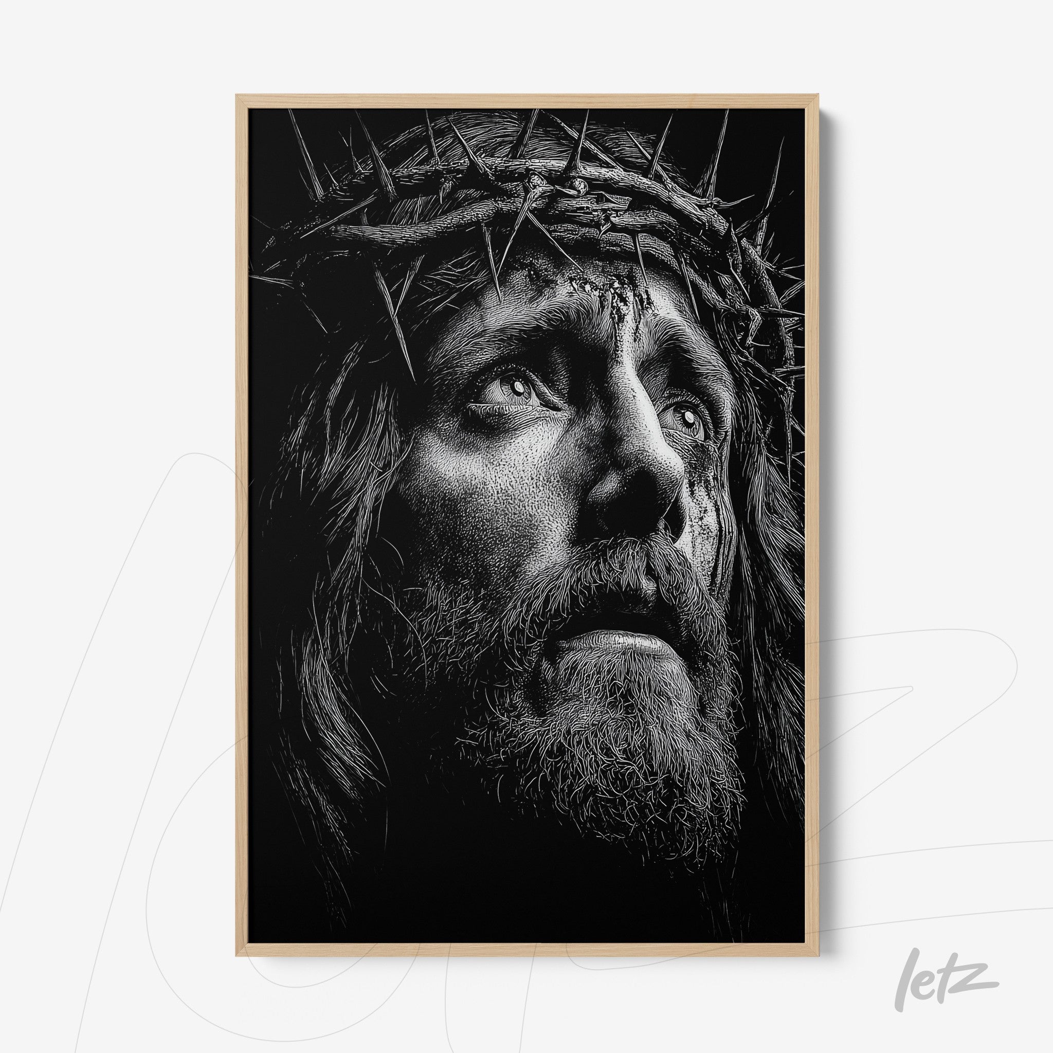 black and white framed art depicting a Christ figure with a crown of thorns and a pained expression in light frame
