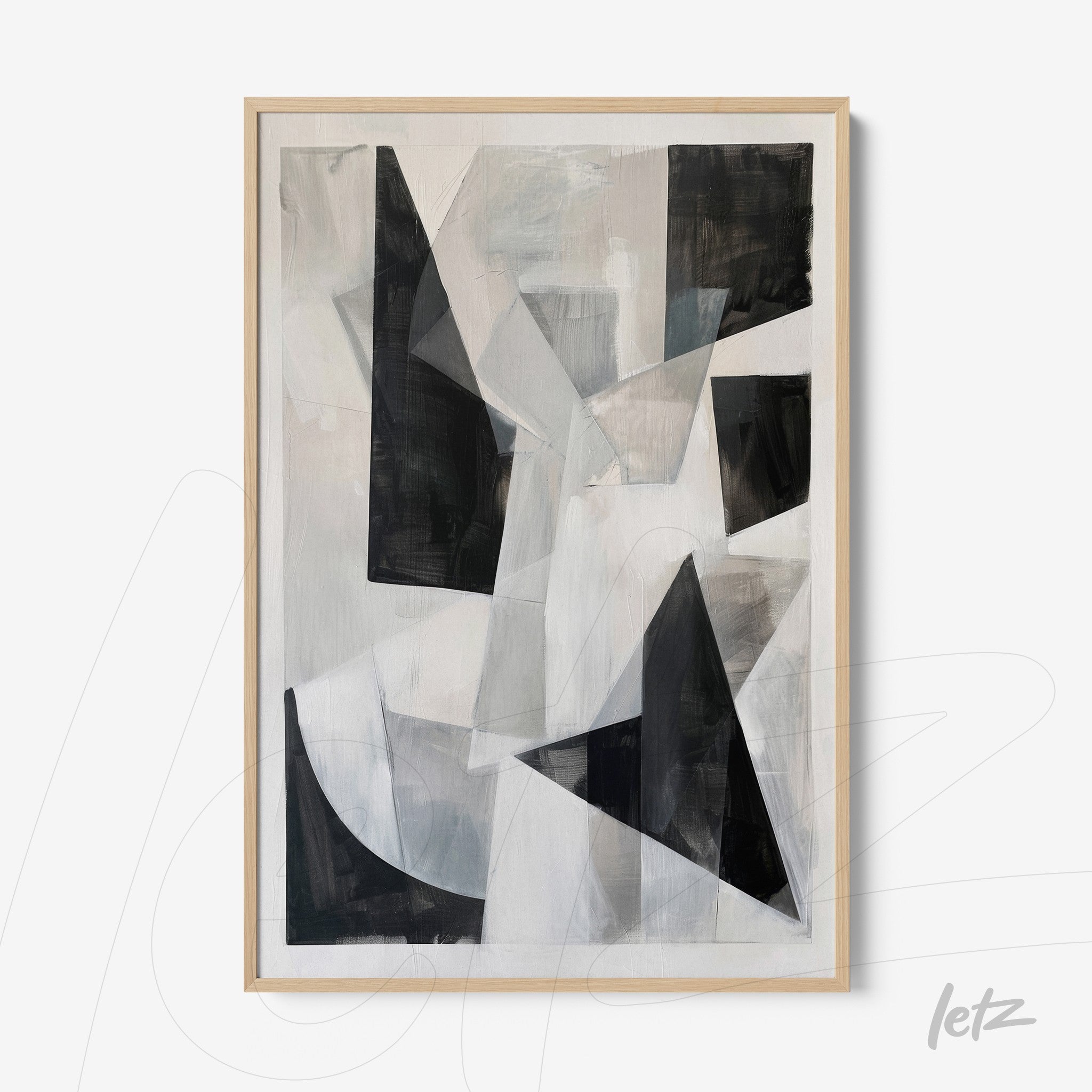 abstract wall art in shades of black, white, and gray framed in light wood