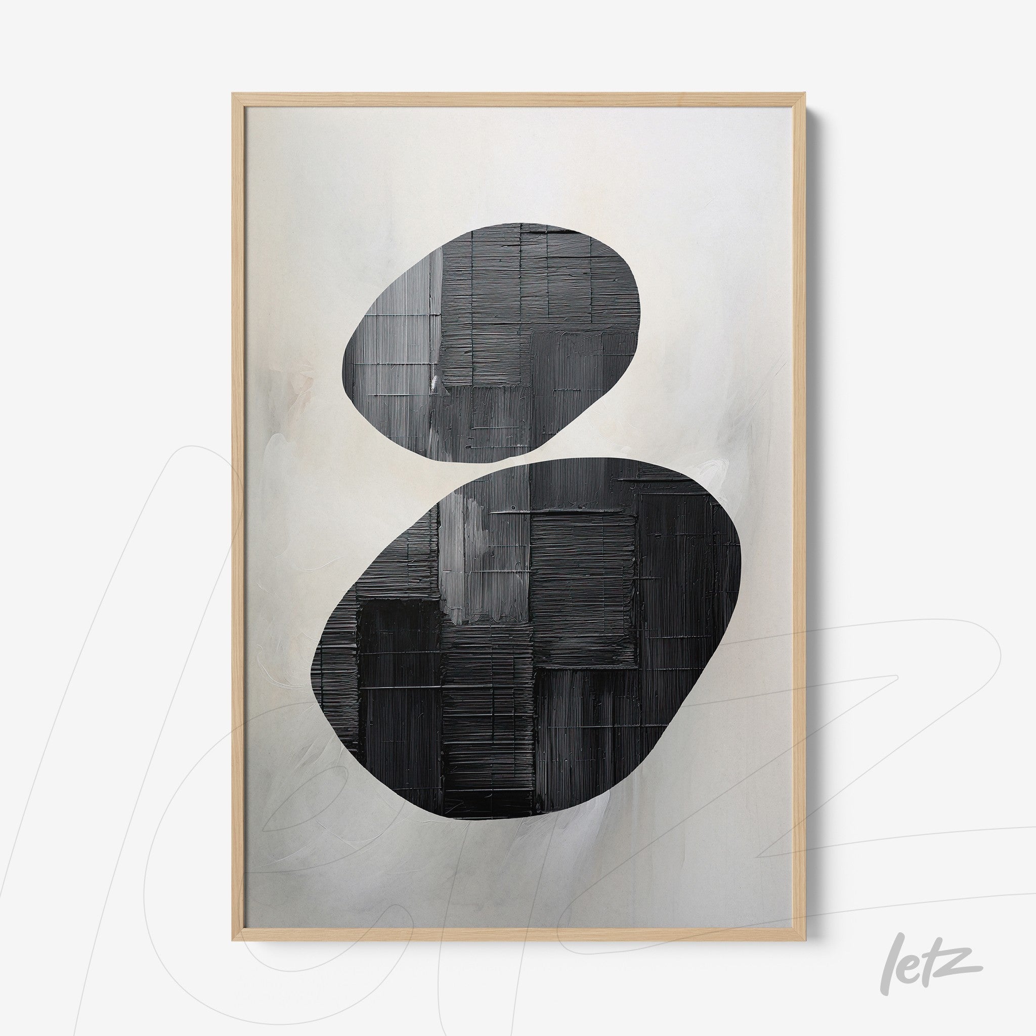 abstract wall art featuring black oval shapes on a light background with a light wood frame