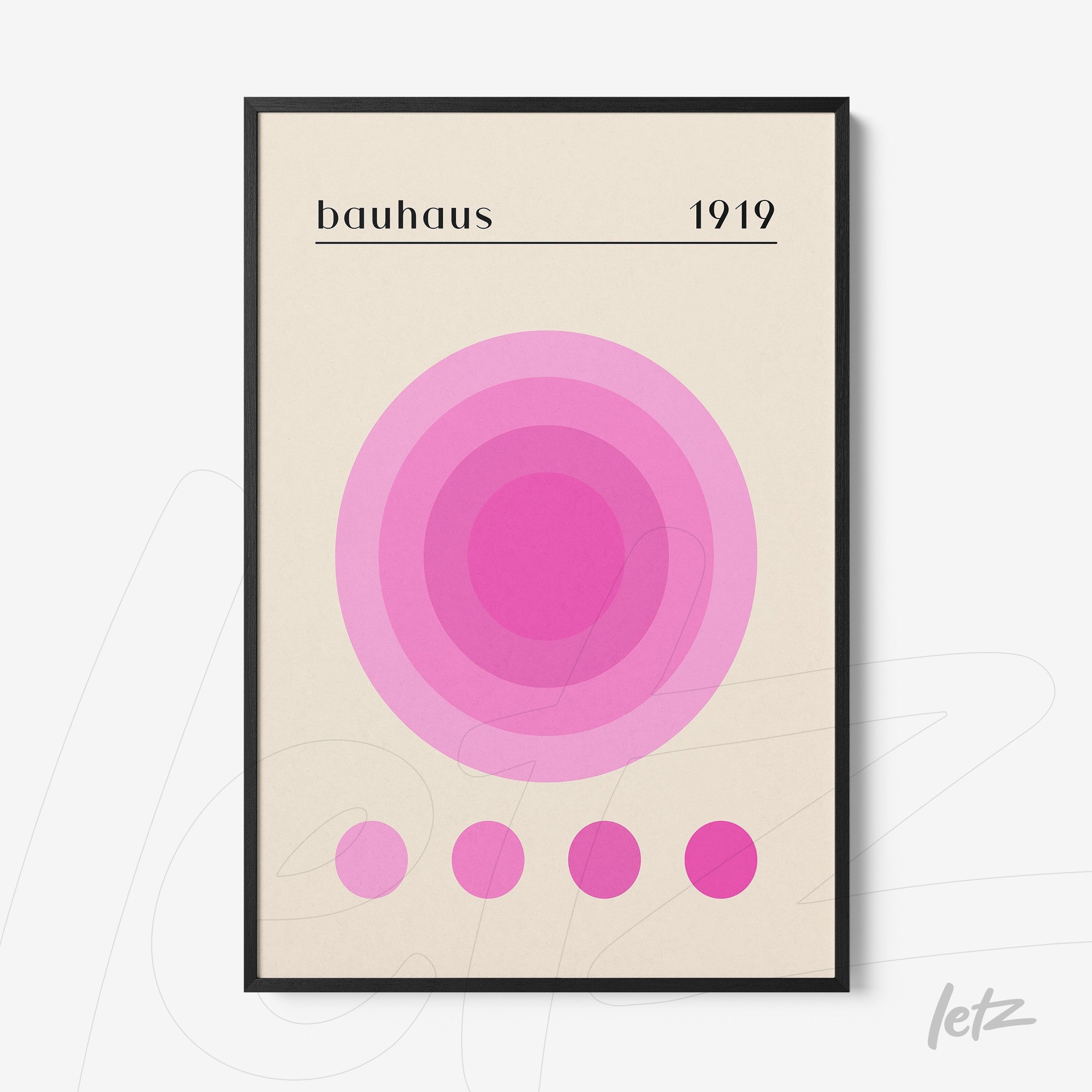 poster with concentric circles in shades of pink featuring 'bauhaus 1919' text in black frame displayed on white wall