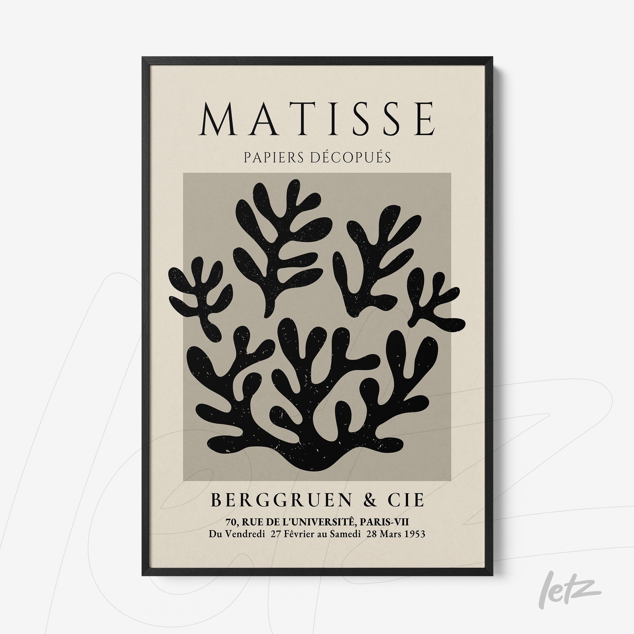 decorative wall art featuring cut-out leaf shapes in black on gray background with thin black frame