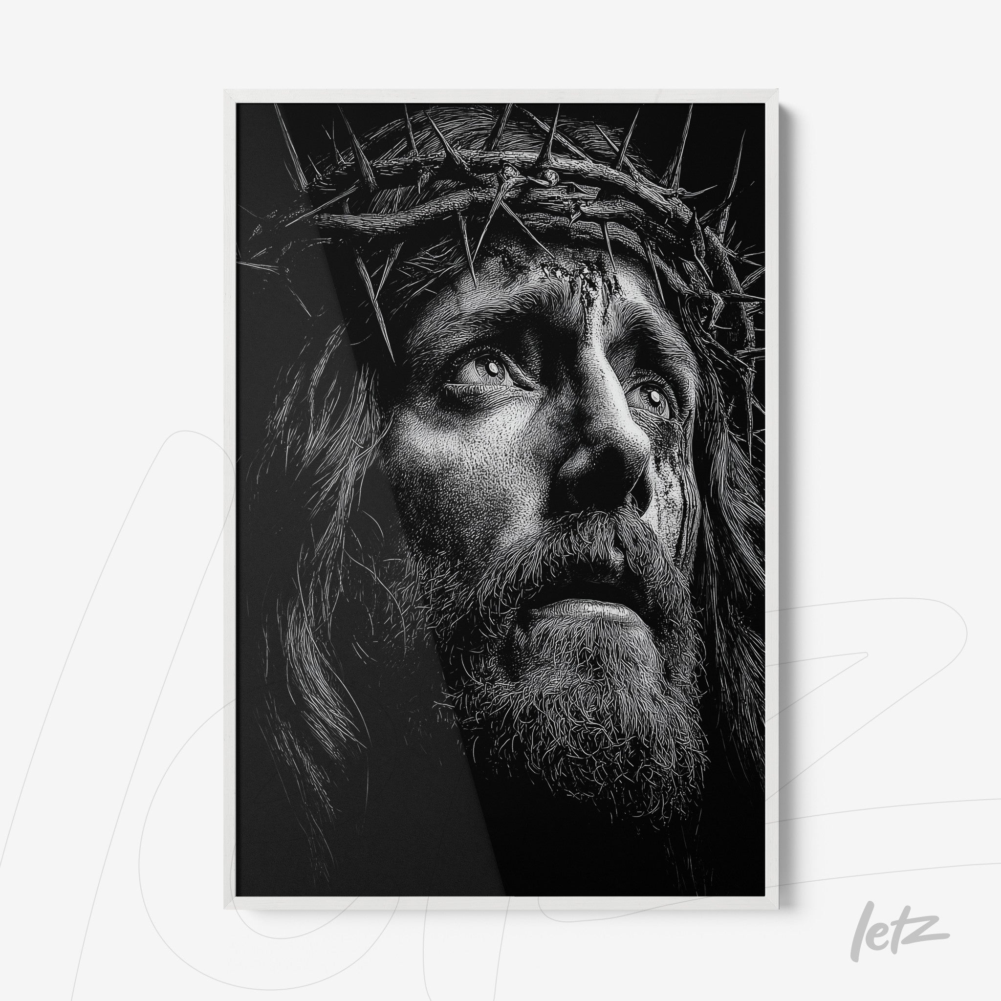 black and white framed wall art depicting the face of Jesus with a crown of thorns in white frame