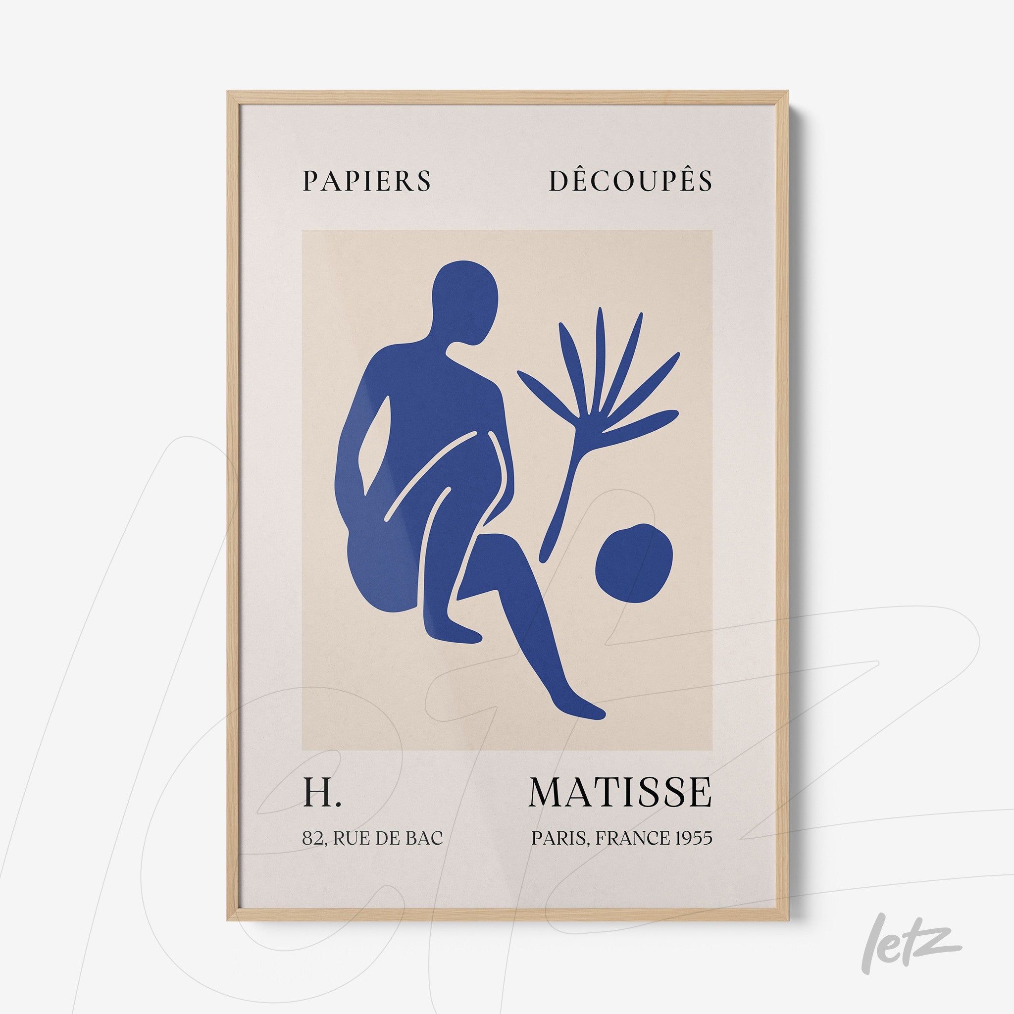 framed artwork of paper cutouts on a light background featuring a blue seated figure beside a plant and a circle with text details at the top