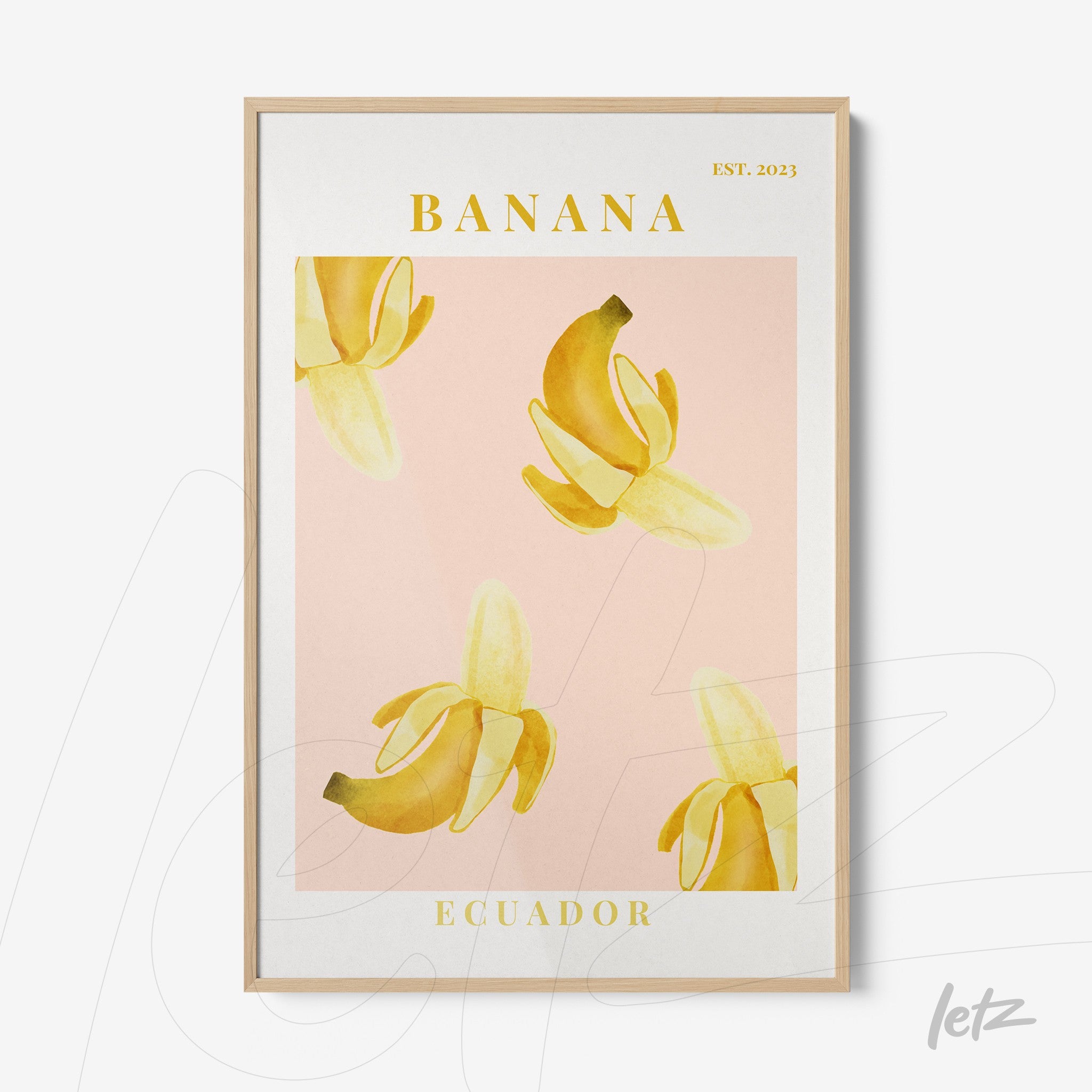 framed art print of bananas on pink background with light wood frame