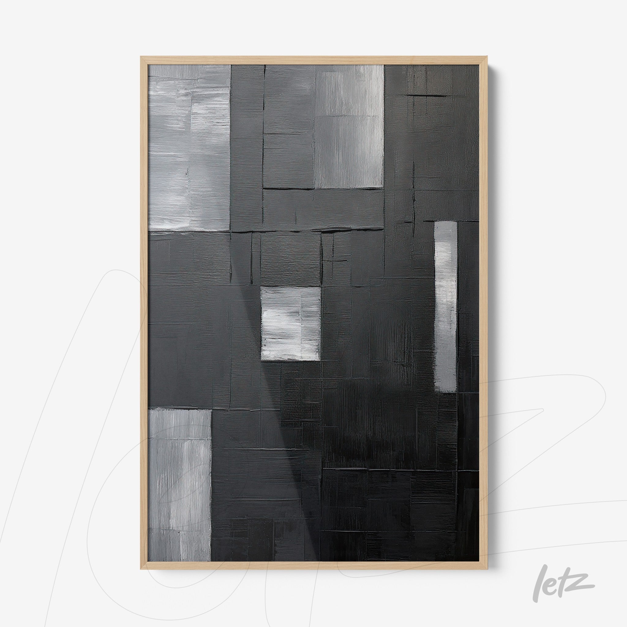 abstract wall art in shades of black and gray with light wood frame