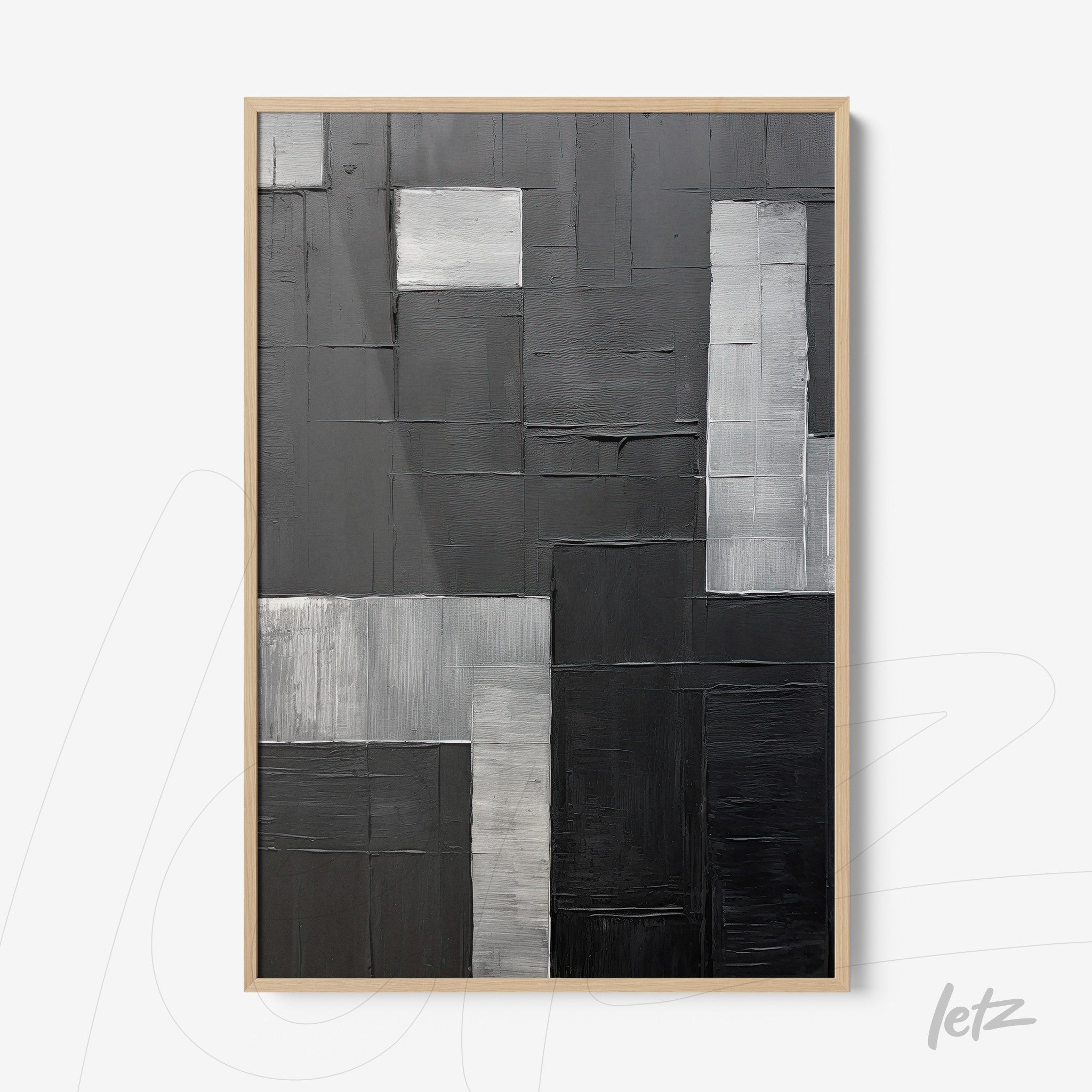 modernist wall art in shades of black and gray framed in light wood