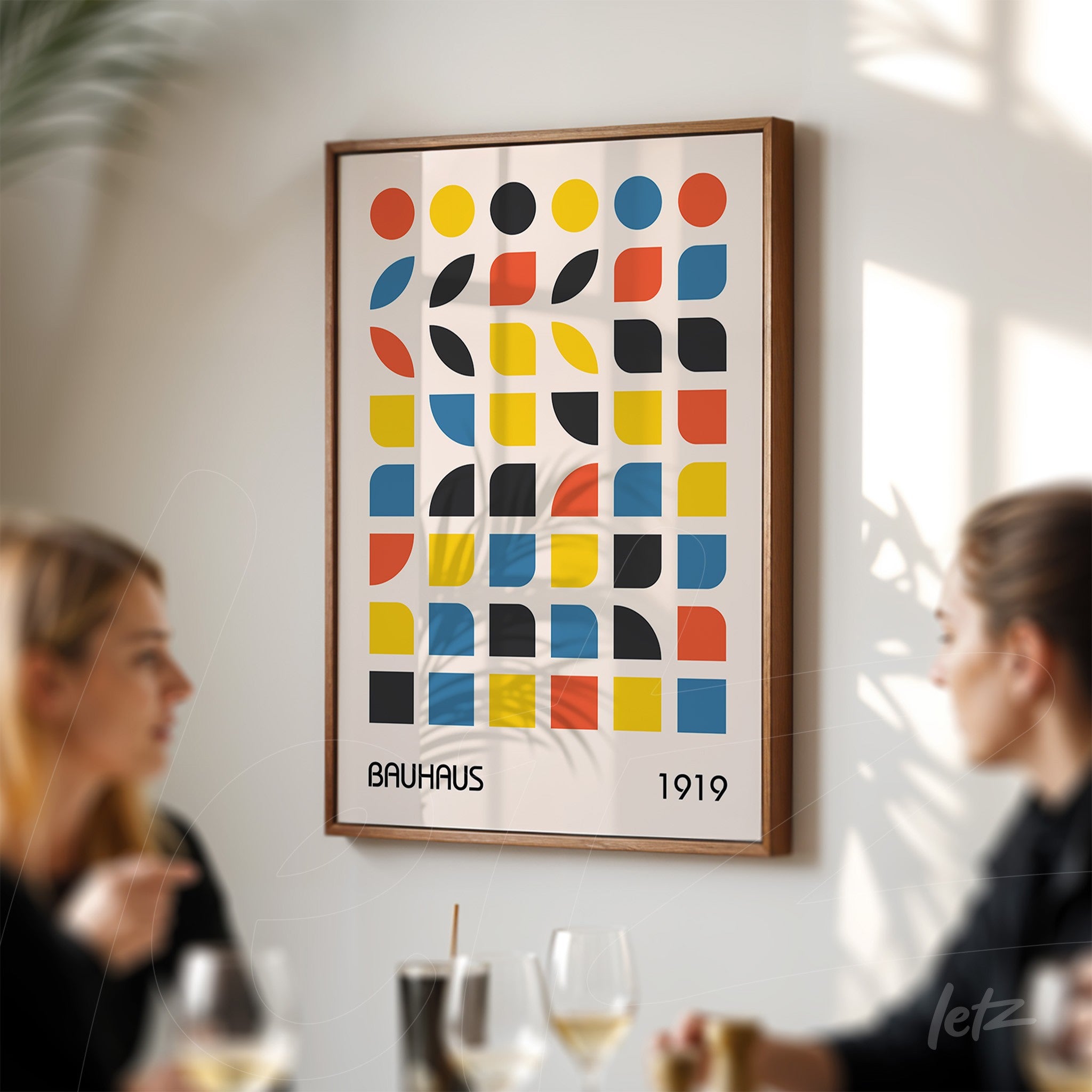 colorful geometric bauhaus style poster print in wooden frame displayed on light wall