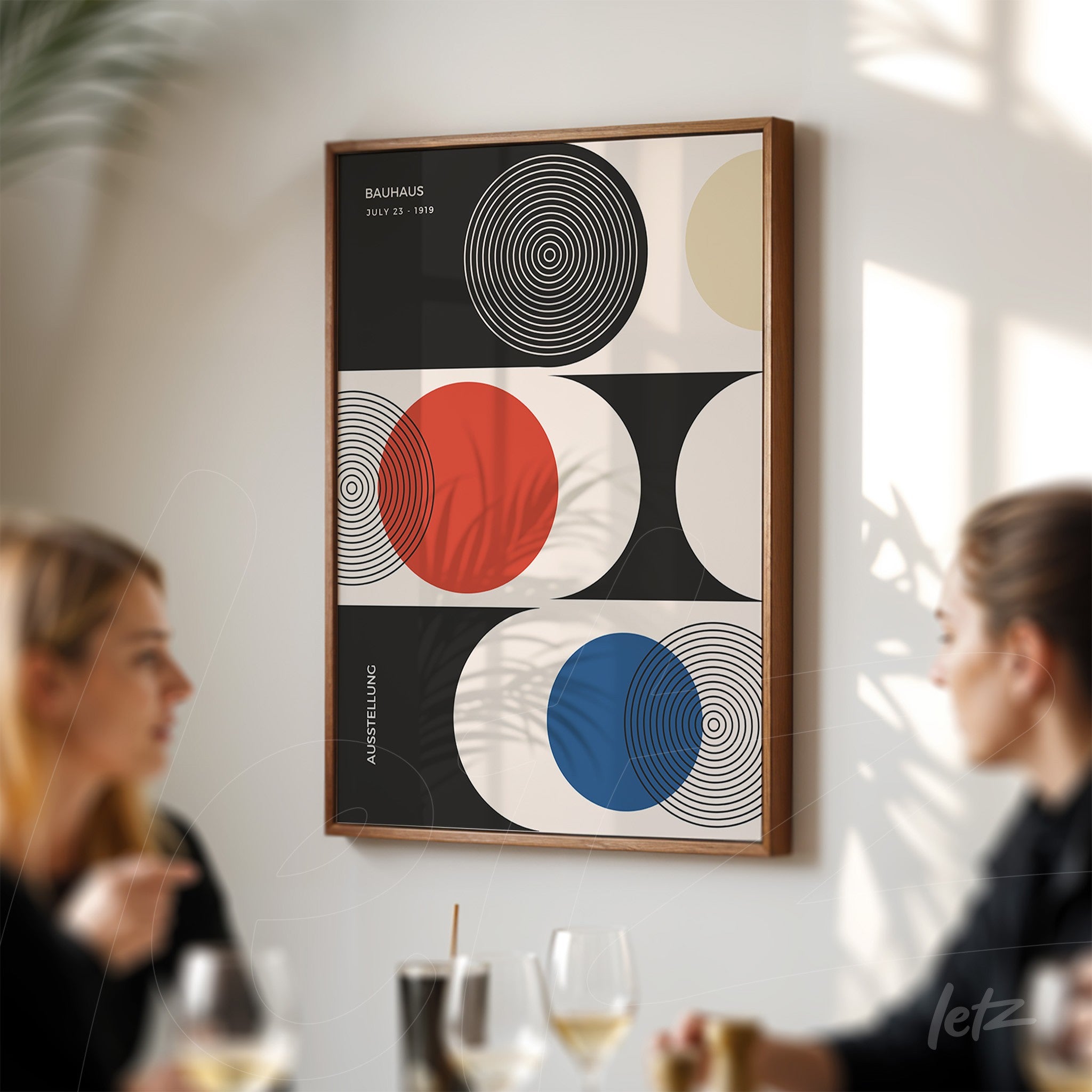 poster featuring geometric art of the Bauhaus movement in a wooden frame displayed on a white wall