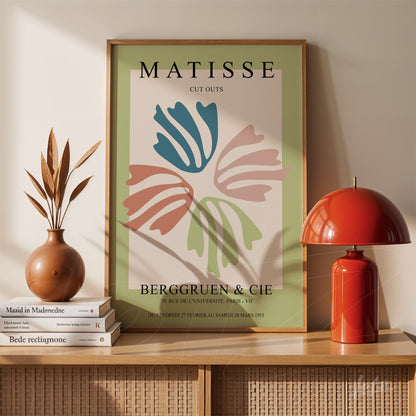 decorative wall art featuring a Matisse cut-out design in light wood frame, showcasing colorful organic shapes on a soft green background above a wooden sideboard