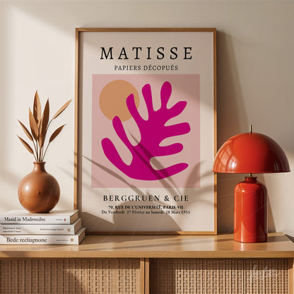 framed wall art inspired by Matisse featuring organic shapes in pink and orange tones displayed on a wooden shelf with a decorative vase and lamp
