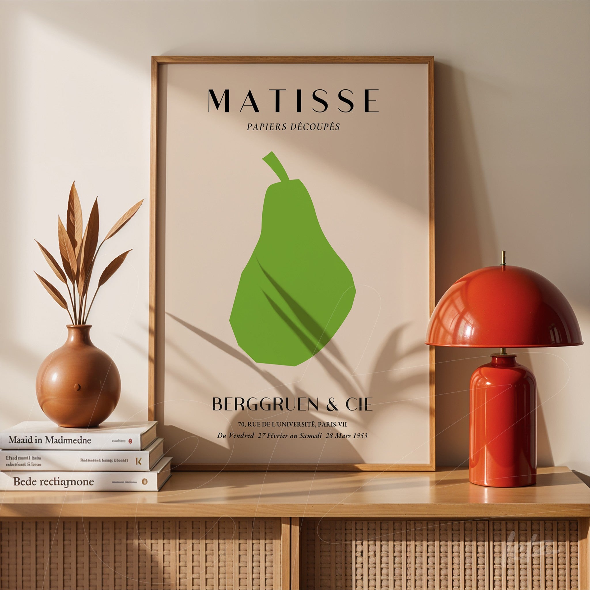 decorative artwork featuring a modern green pear illustration with a simple light wood frame and beige background displayed on a shelf with vases and books