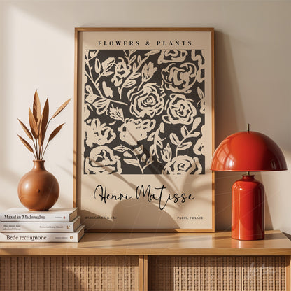 framed wall art featuring floral patterns on a dark background, displayed on a table with a vase and a lamp