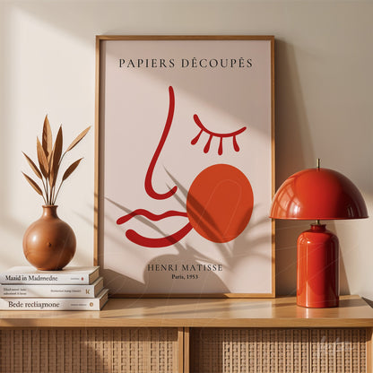 framed artwork by henri matisse featuring simple line art of a face in a minimalist style with an orange circle beside it