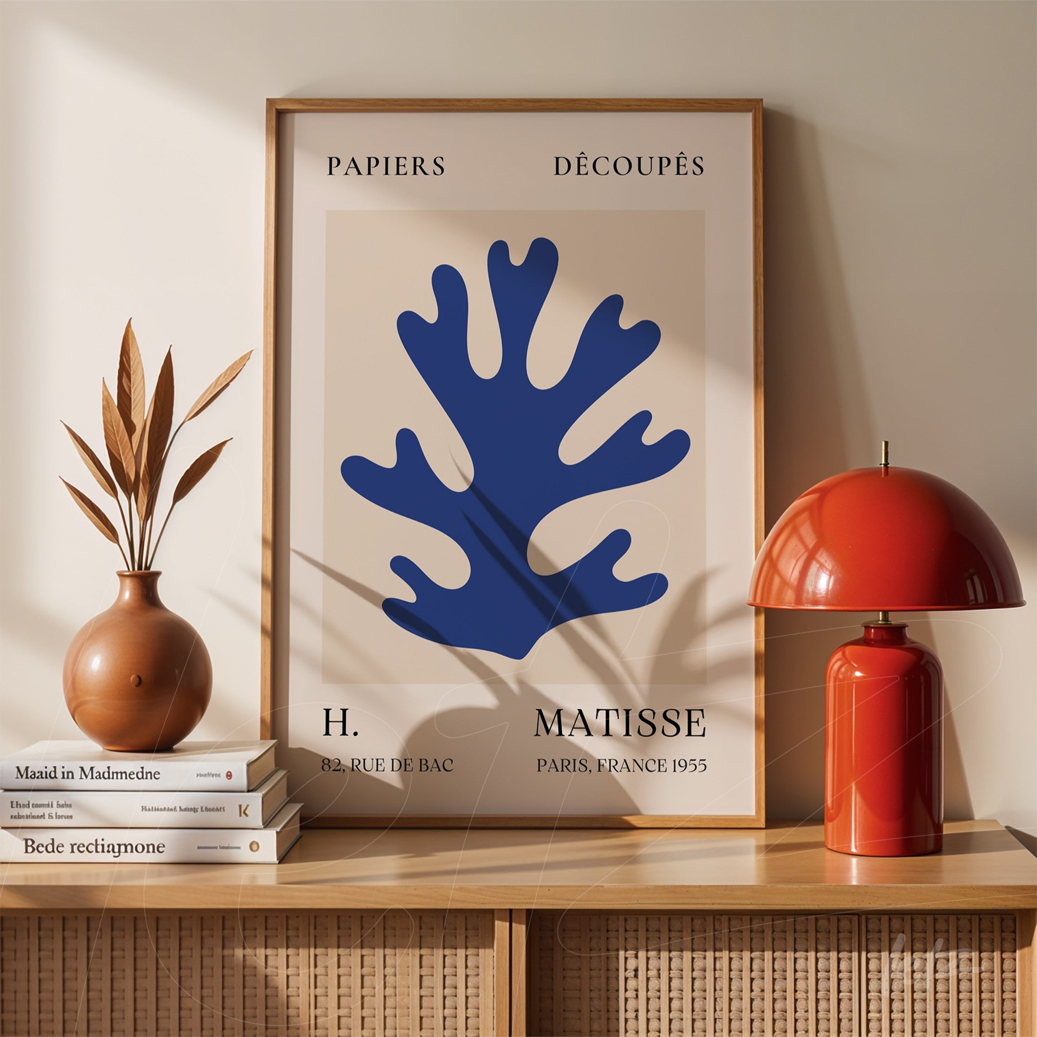 framed modern wall art featuring a blue outline design displayed on a wooden table with decorative vases