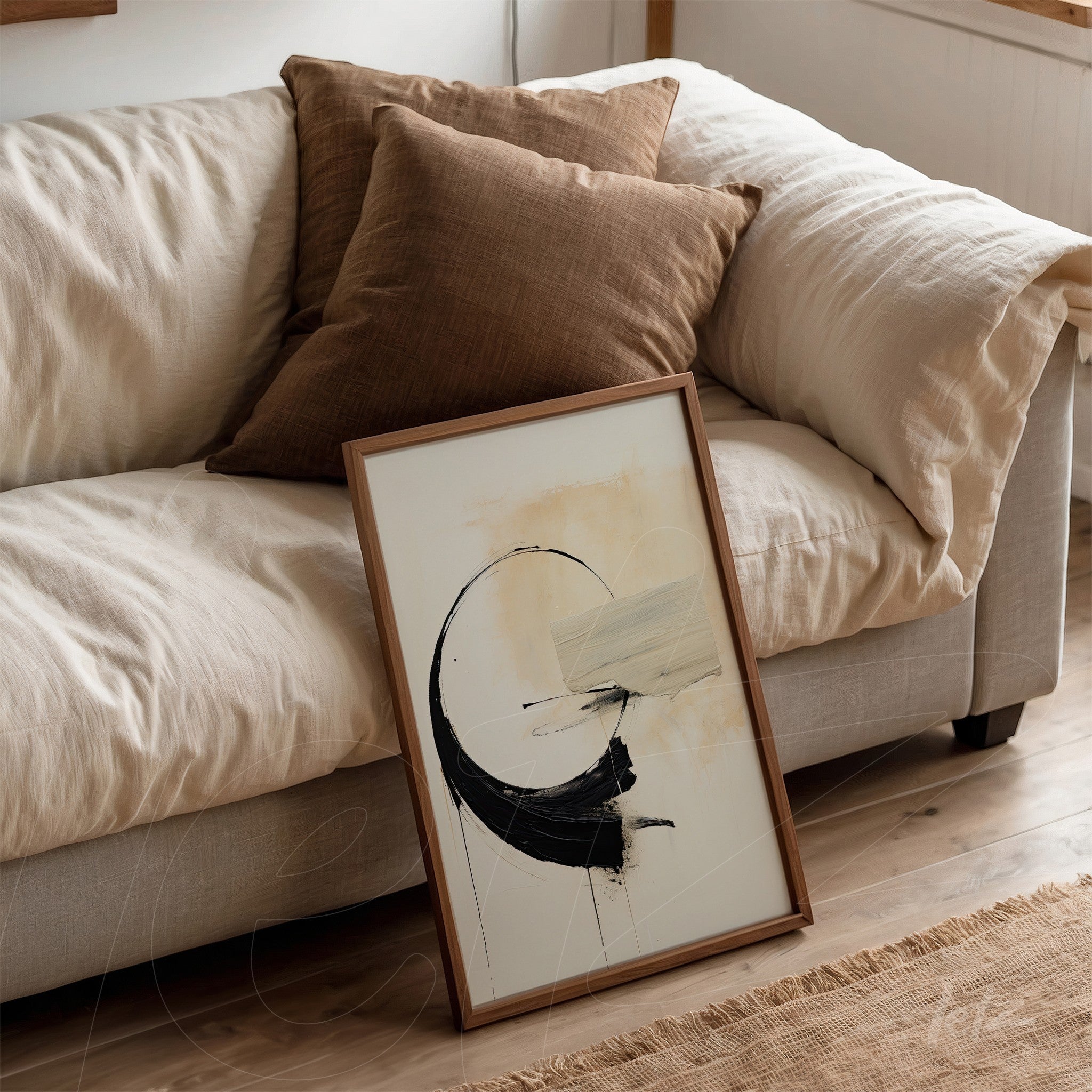 framed abstract art piece with wooden frame leaning against a sofa with brown cushions