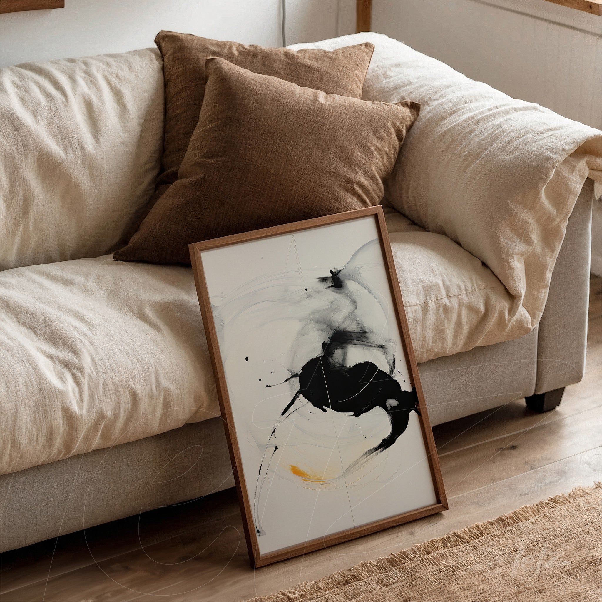 framed abstract art in black and white with yellow accents, leaning against a light sofa with textured cushions