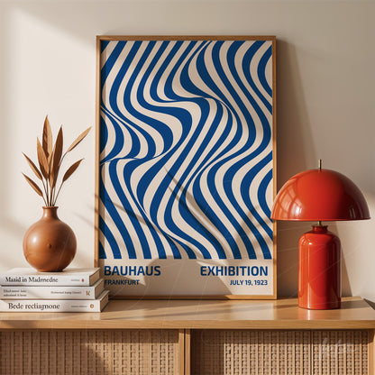 bauhaus style poster print with blue wavy patterns and exhibition text in wooden frame on sideboard