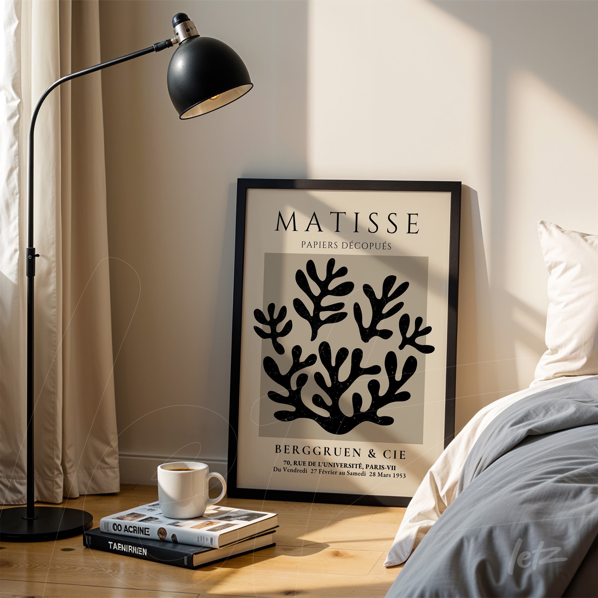decorative wall art featuring paper cutouts in black on a light background, framed in black, leaning against wooden floor next to a floor lamp