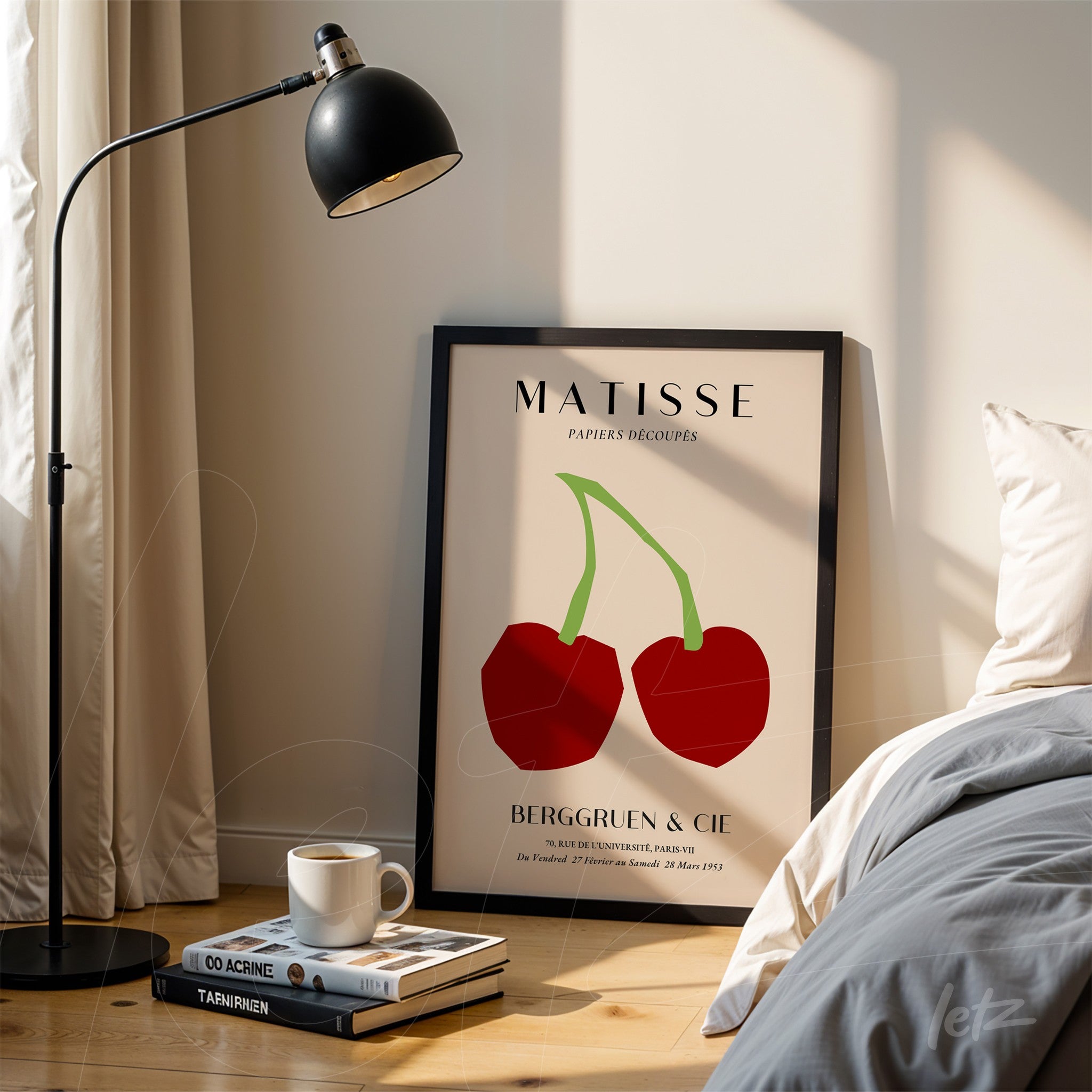 framed wall art featuring modern minimalist illustration of cherries in black frame displayed next to a lamp on wooden table near a bed with light bedding