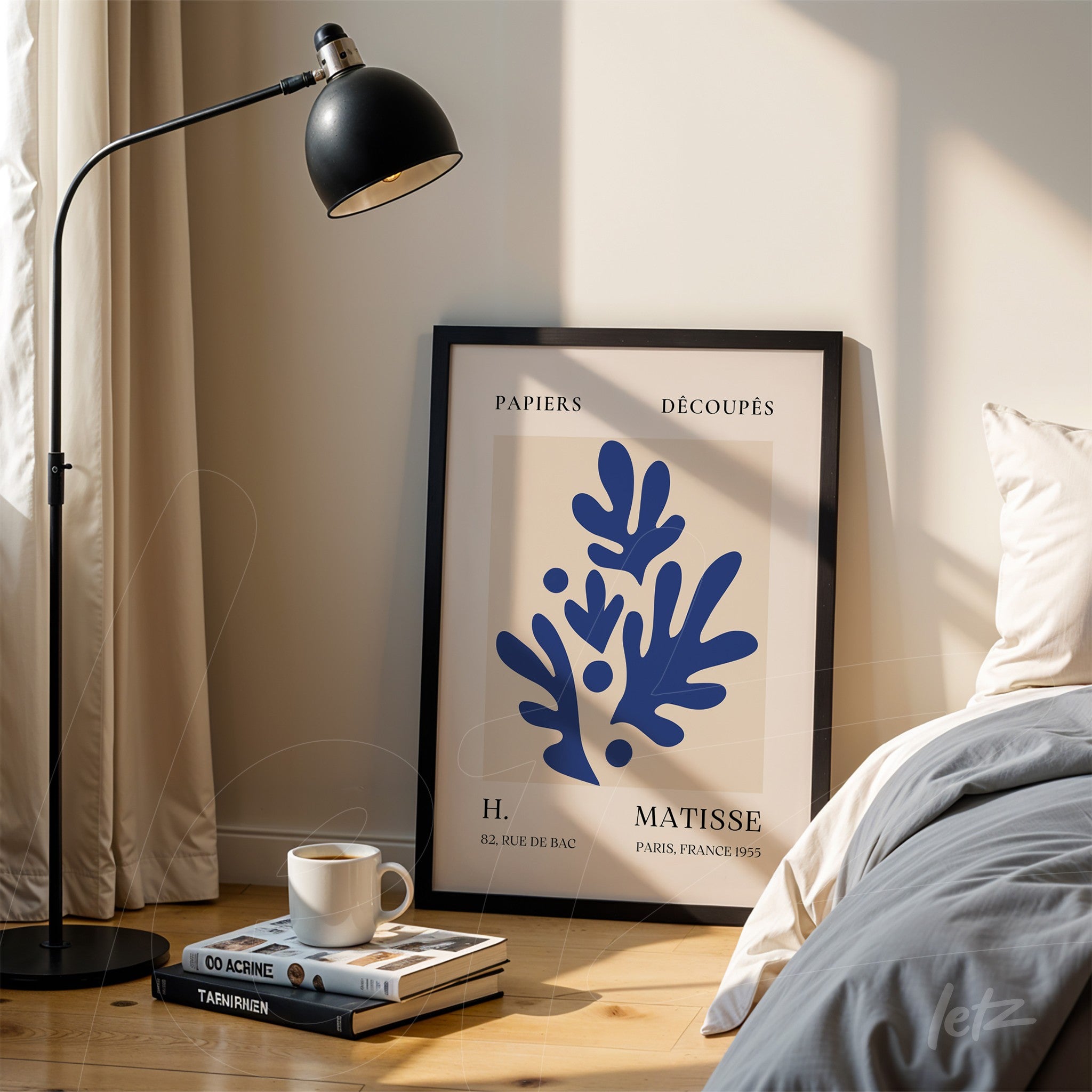 decorative framed artwork featuring modern blue organic shapes on a light background, black frame displayed in a well-lit setting with a floor lamp