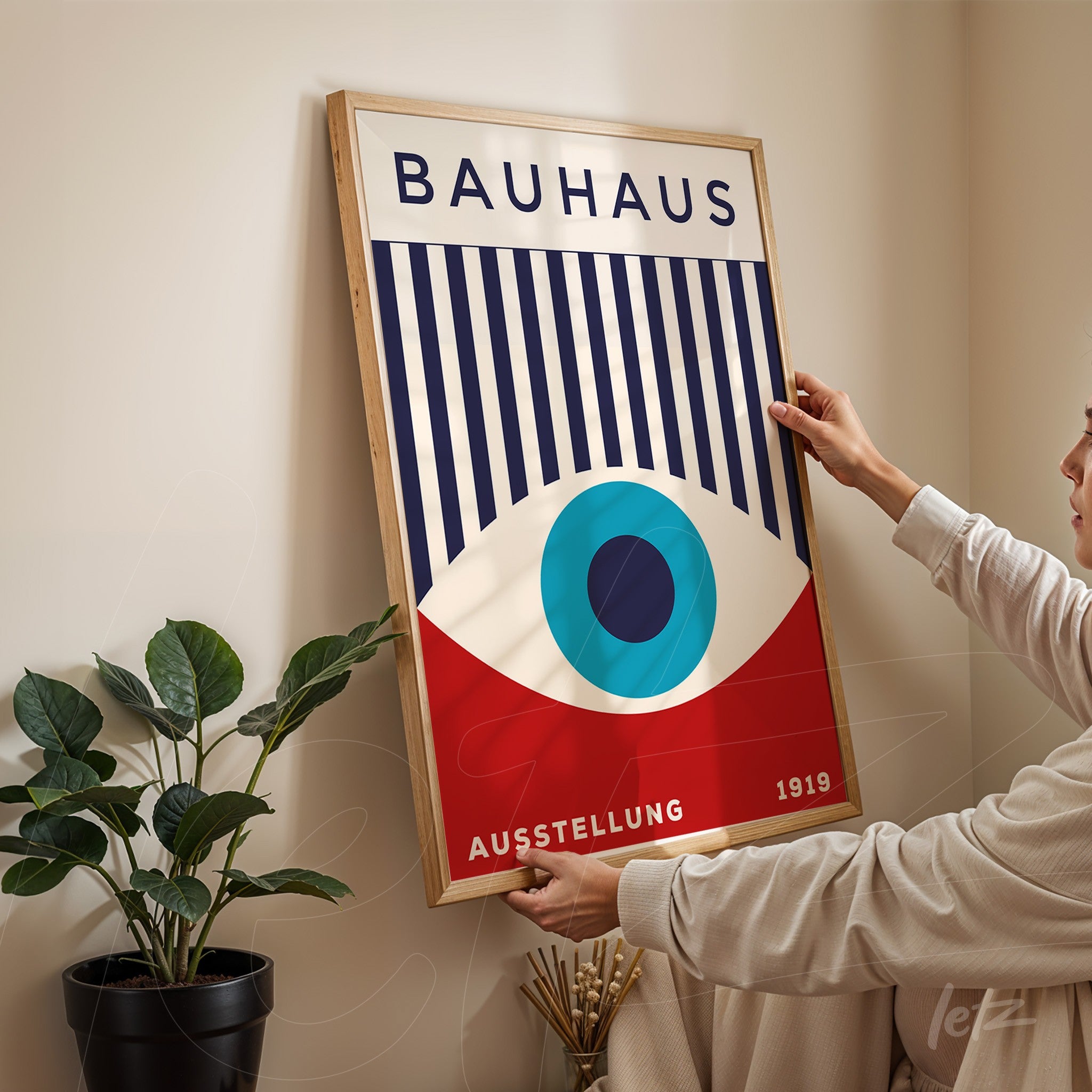 bauhaus style poster art featuring abstract eye in blue and red hues with light frame against beige wall