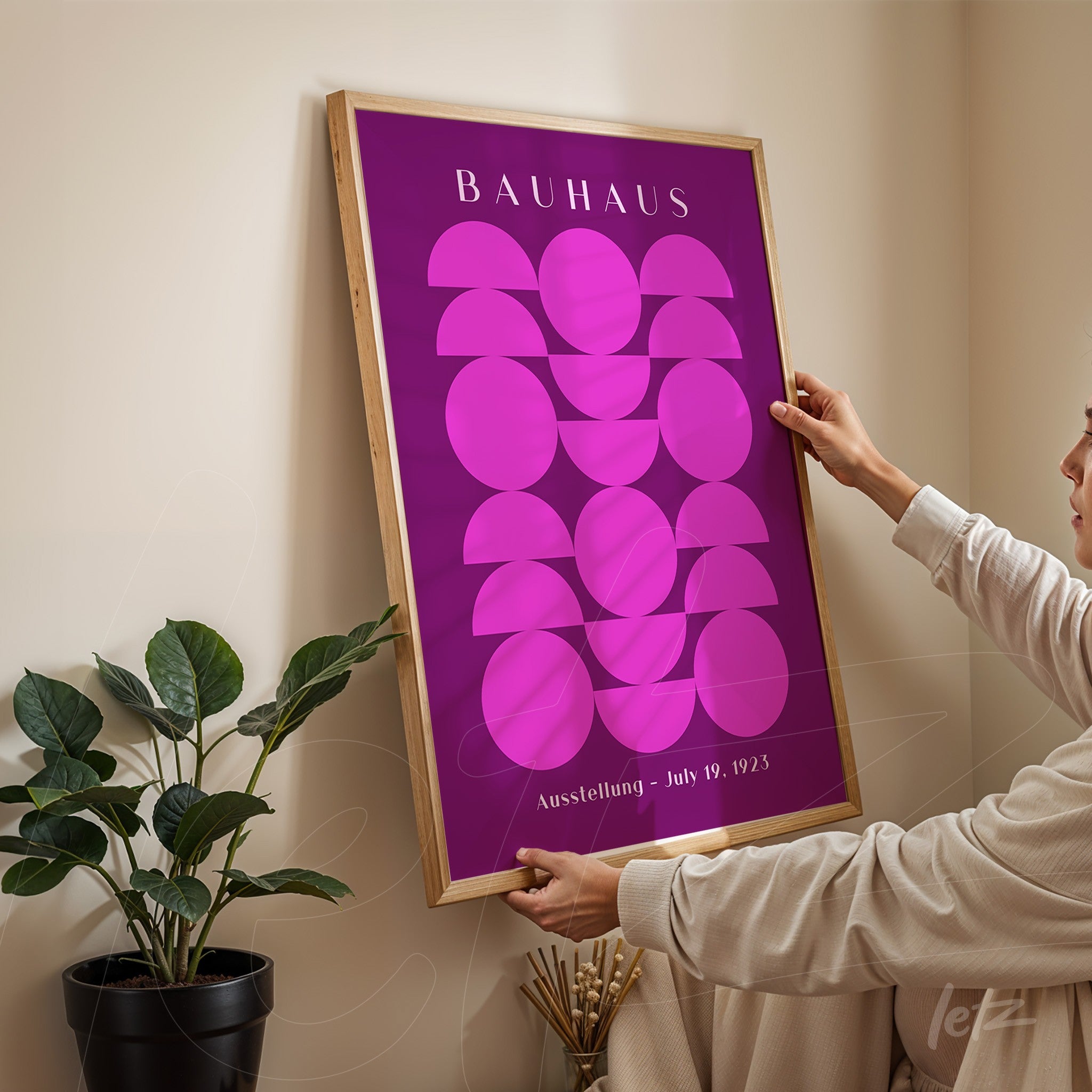 poster print featuring geometric bauhaus style art with a light wooden frame held by a person