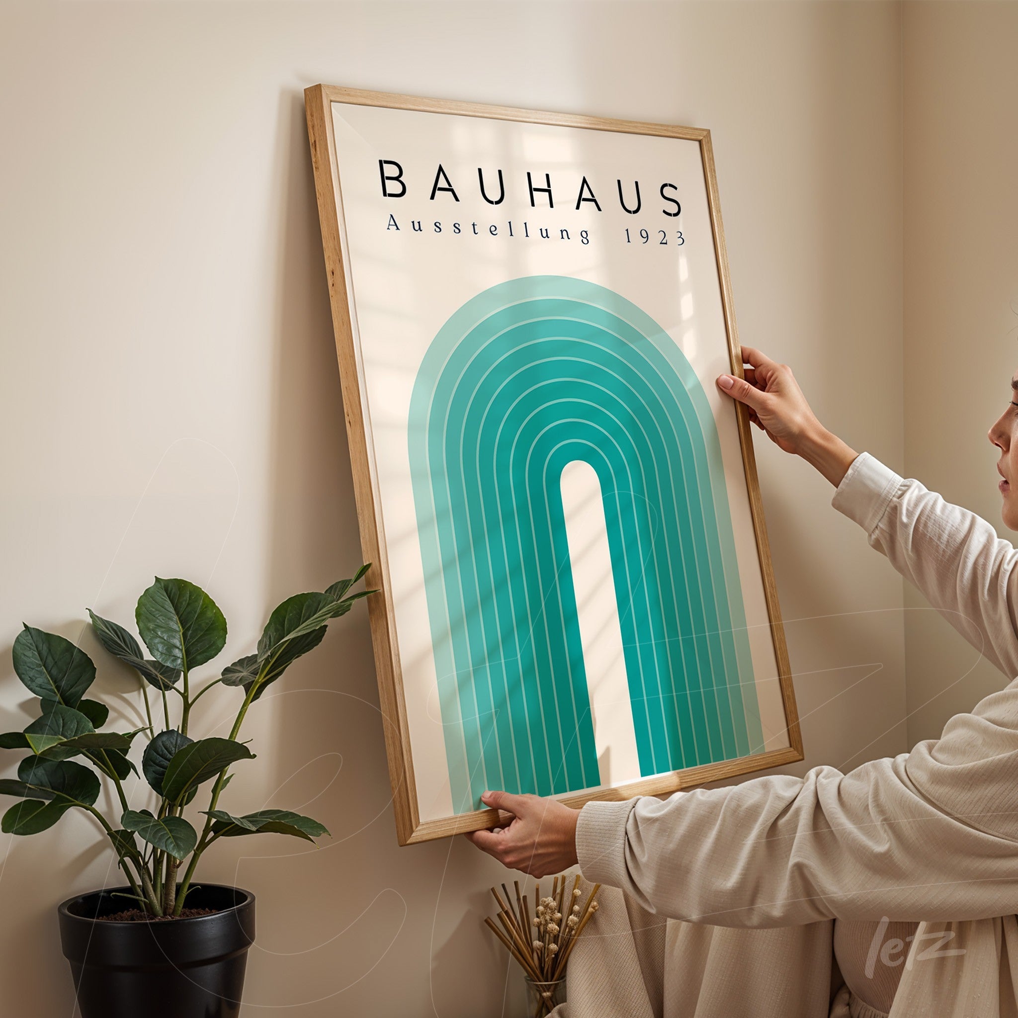 bauhaus style poster with geometric design from 1923 in light wooden frame held by a person in a brightly lit room