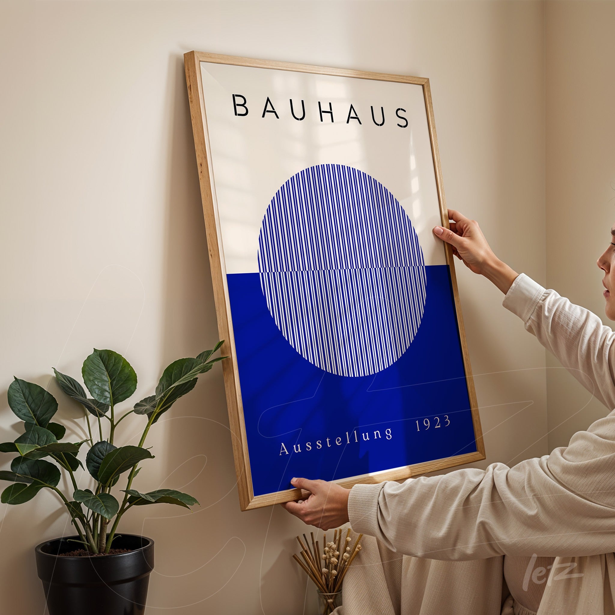 minimalist bauhaus school poster design in a light wood frame displayed on a beige wall
