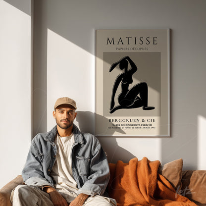 framed modern art featuring a silhouette of a female figure against a light wall, alongside a man wearing a denim jacket and cap