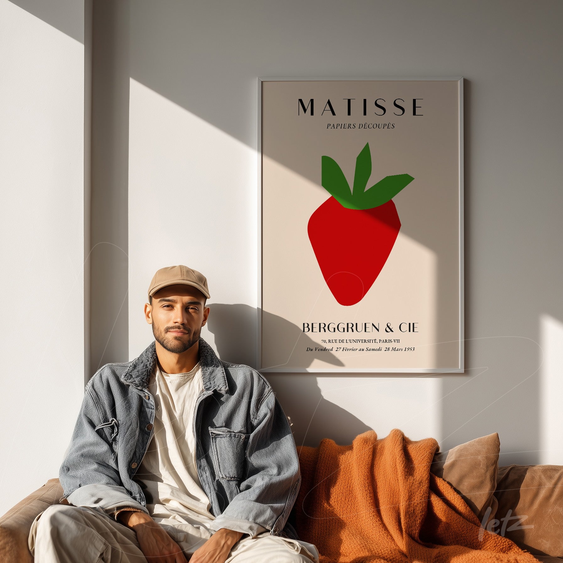 framed art inspired by Matisse featuring a red strawberry on a neutral background, displayed against a light wall with a brown sofa