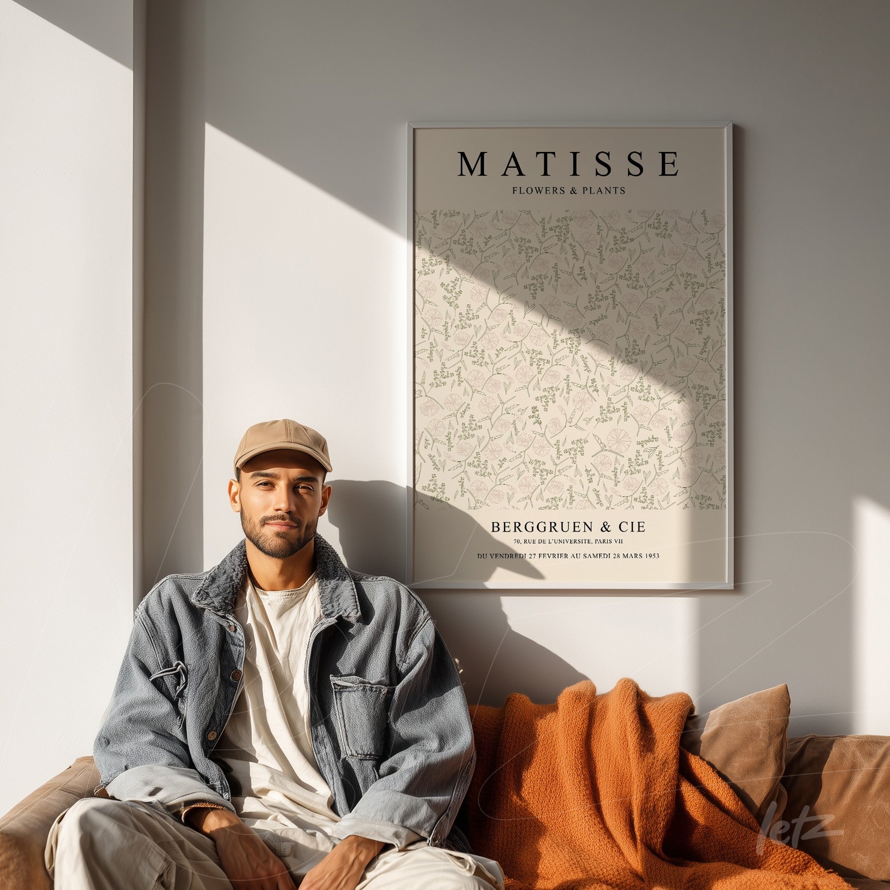 framed wall art featuring floral design by Matisse, displayed next to a man sitting on a brown sofa