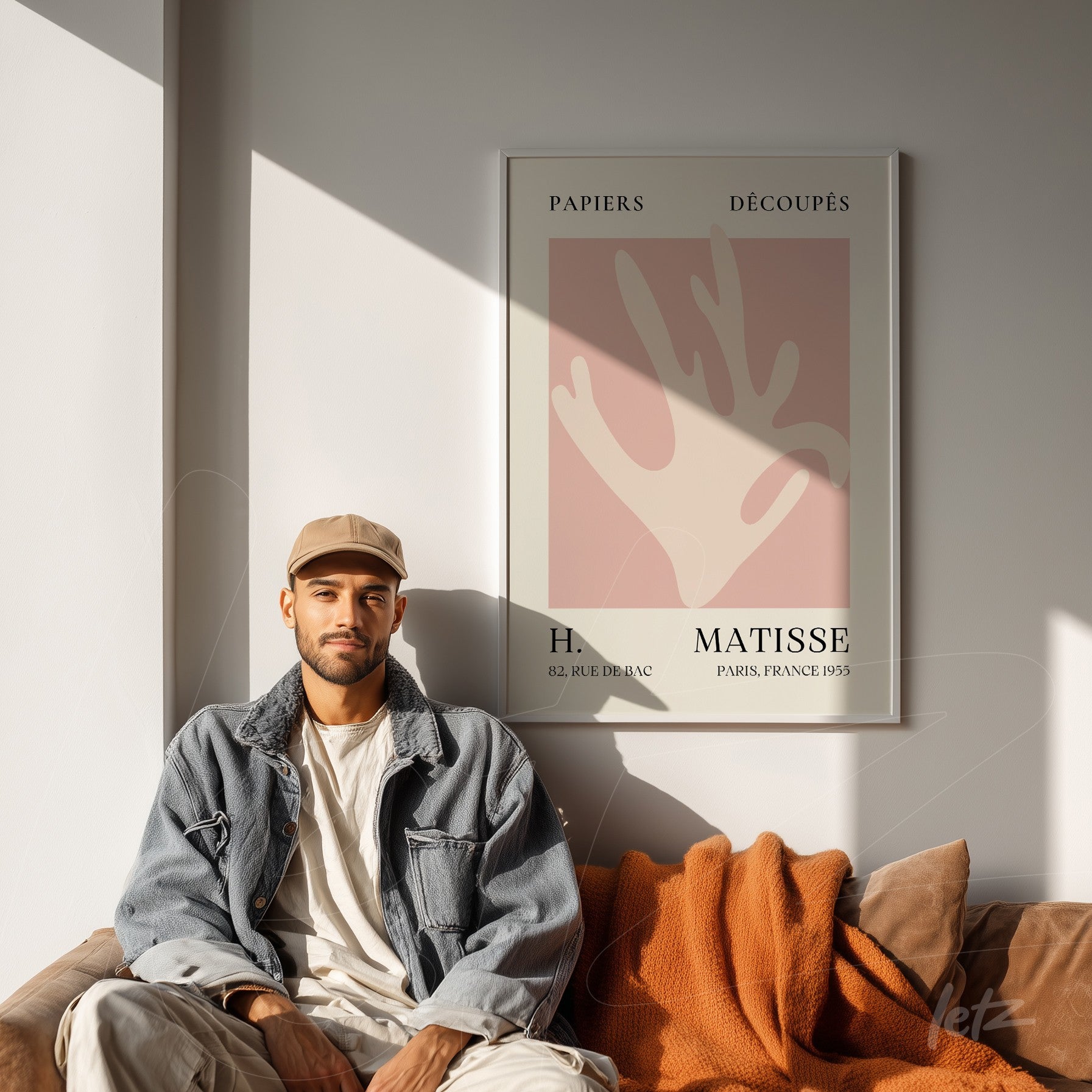 framed modern art print featuring light pink background and abstract shapes, displayed in a room with a sofa and natural light