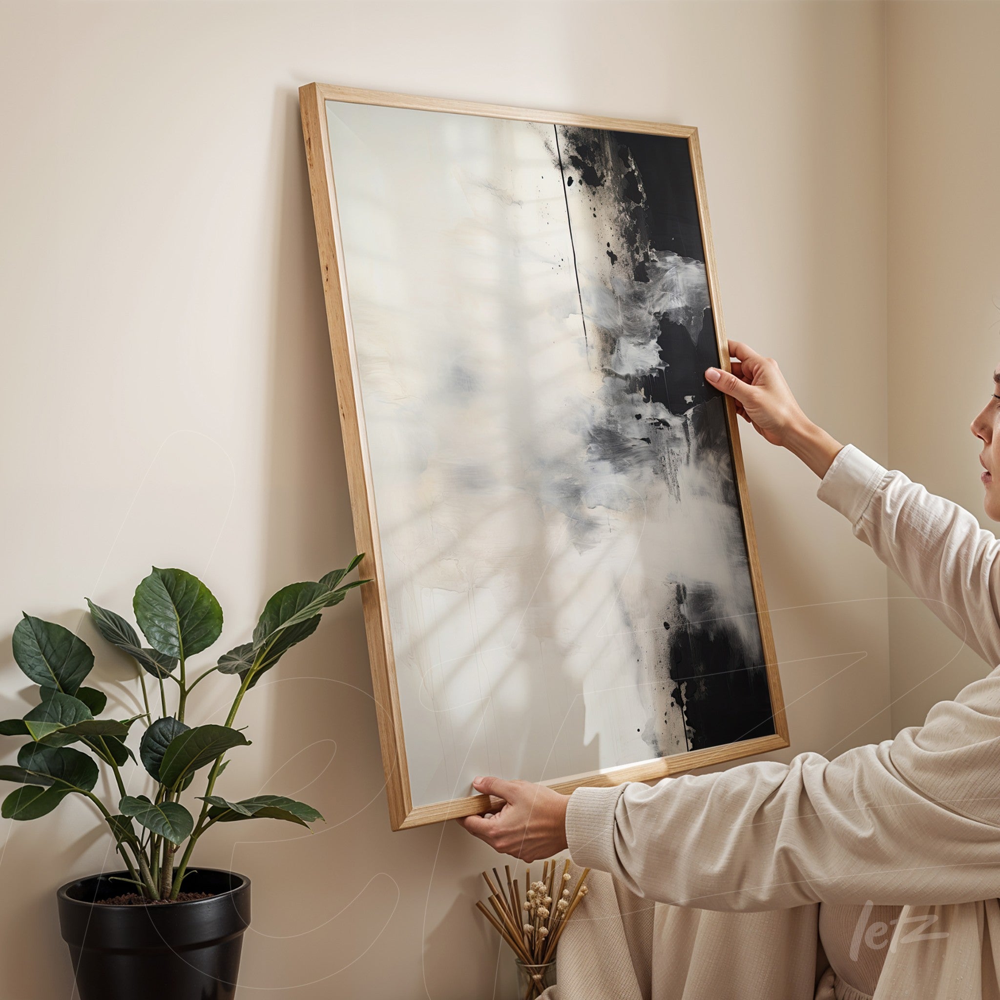 abstract framed wall art in light wood featuring a predominance of black and white, displayed against a light wall