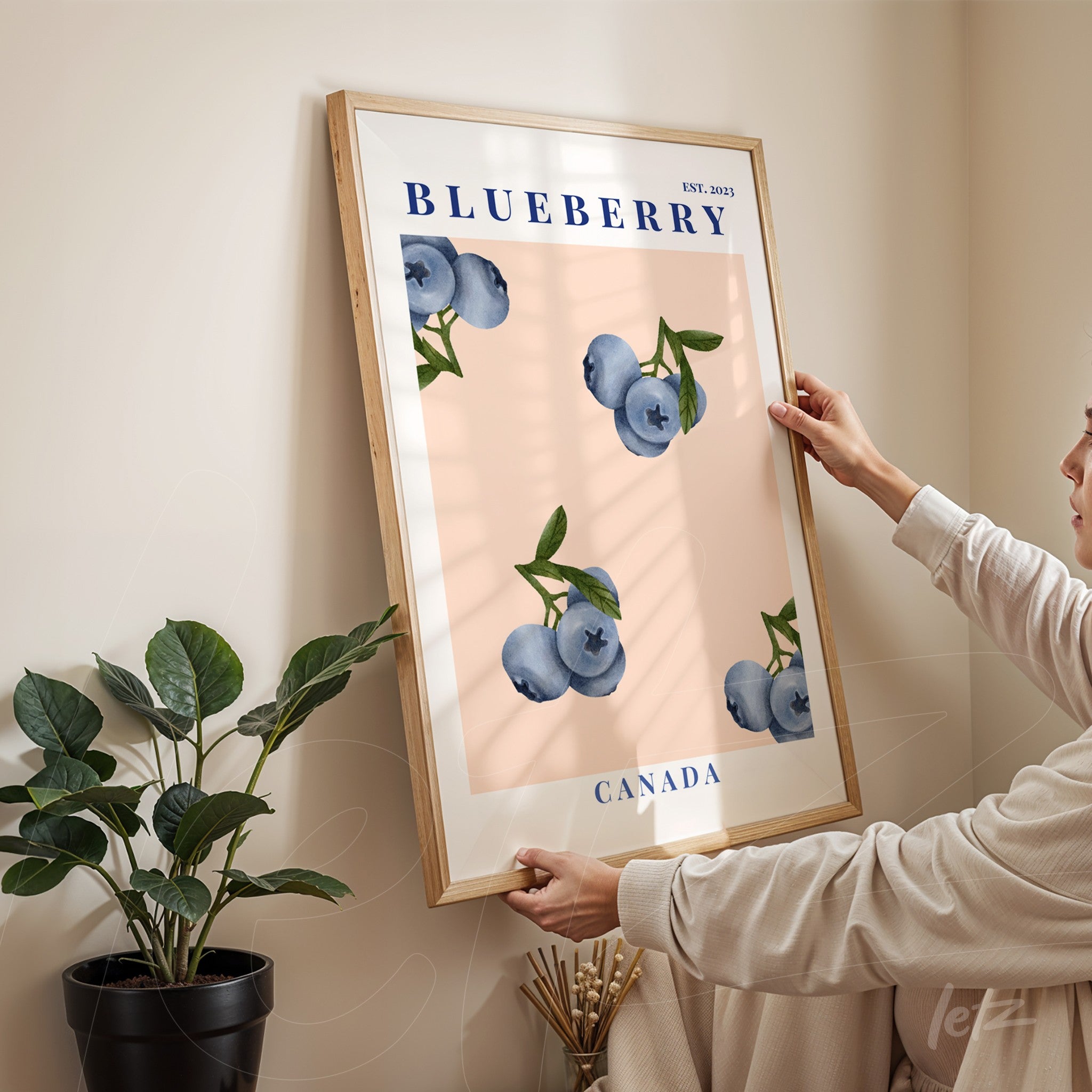 framed wall art featuring blueberries with a light wood frame displayed against a neutral colored wall