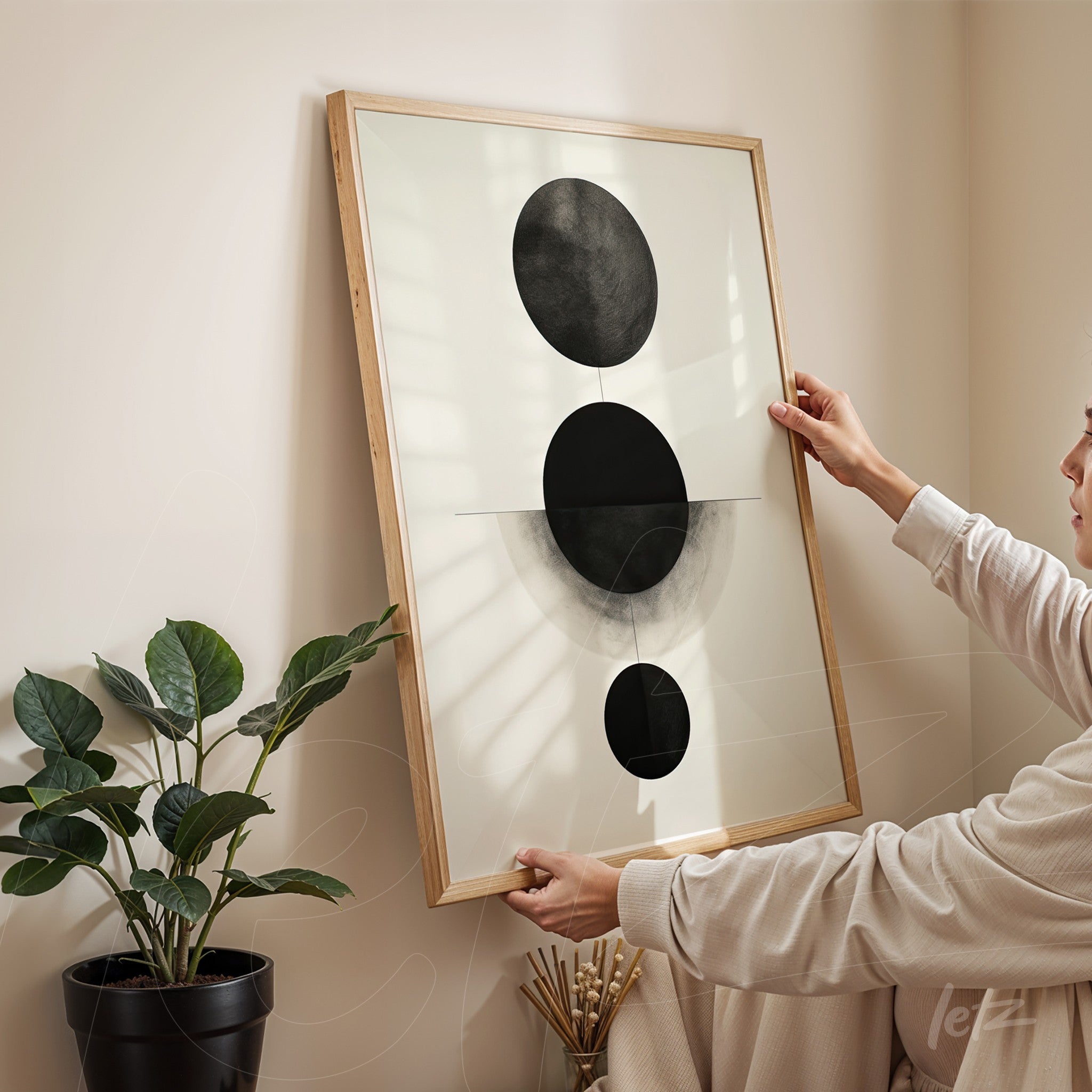 abstract black and white wall art featuring circular shapes in a light wooden frame