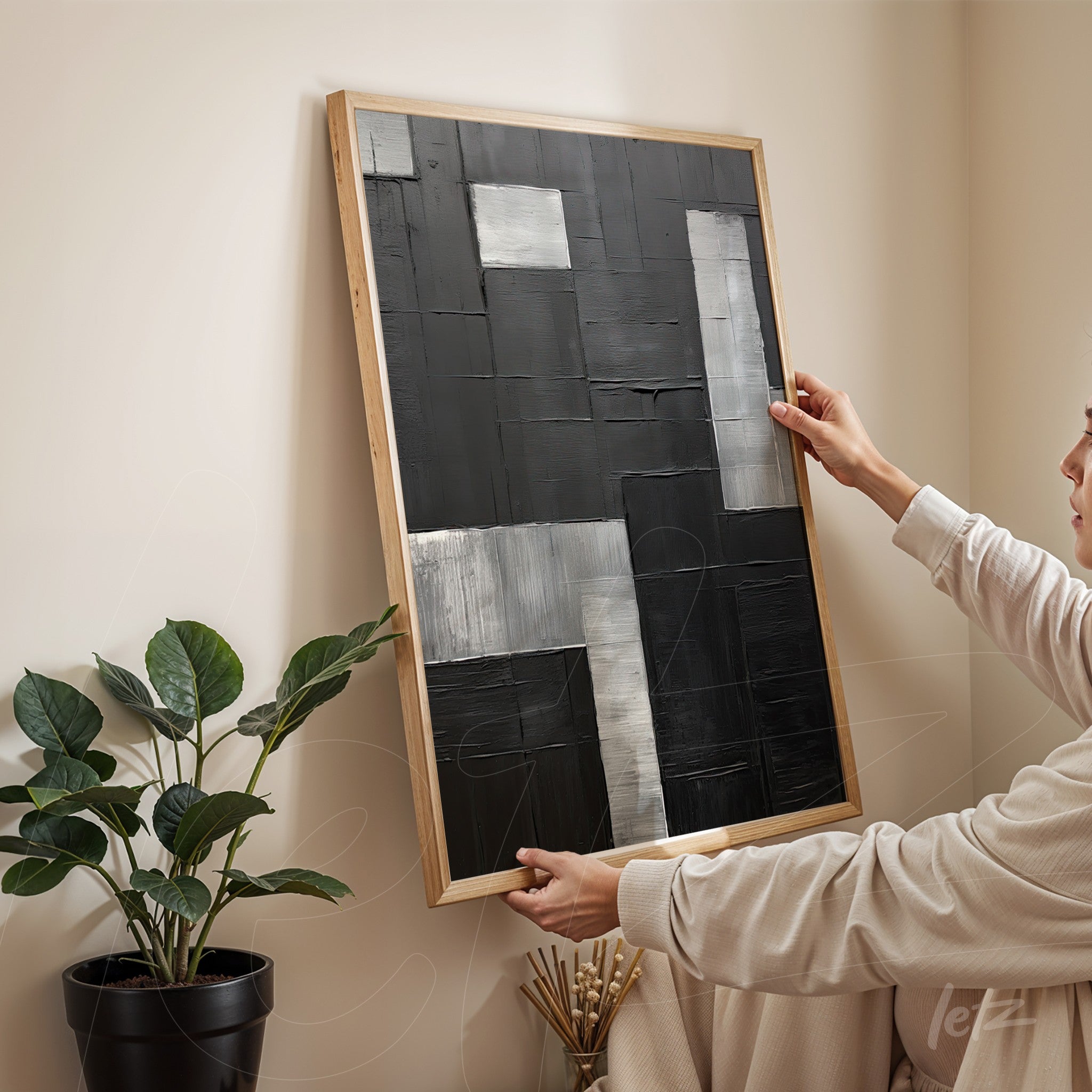 abstract wall art featuring geometric shapes in black and silver tones with light wood frame