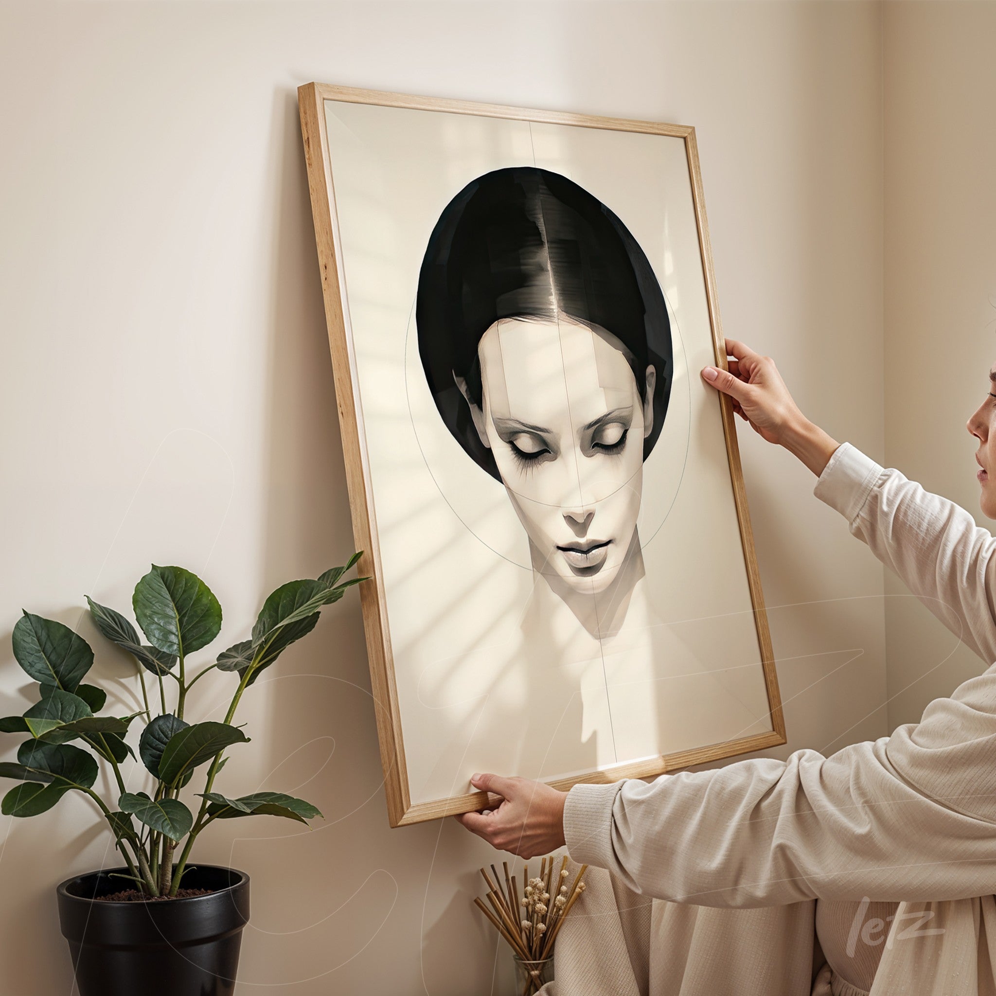 minimalist wall art featuring a female portrait in a light wood frame, held by a person in a well-lit indoor setting