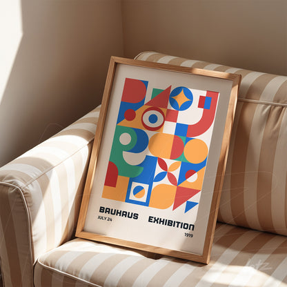 poster print featuring geometric bauhaus style art in light wood frame, placed on a beige and white striped sofa