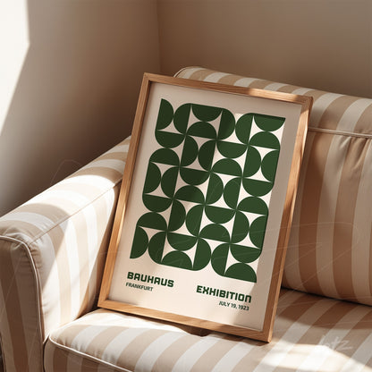 poster featuring green geometric design in light wood frame resting on striped sofa