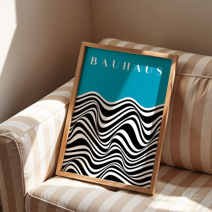 framed poster with geometric illustration of black and white waves on a light blue background, resting on a beige striped sofa