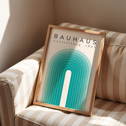 bauhaus style geometric art print in a light wood frame resting on a striped sofa