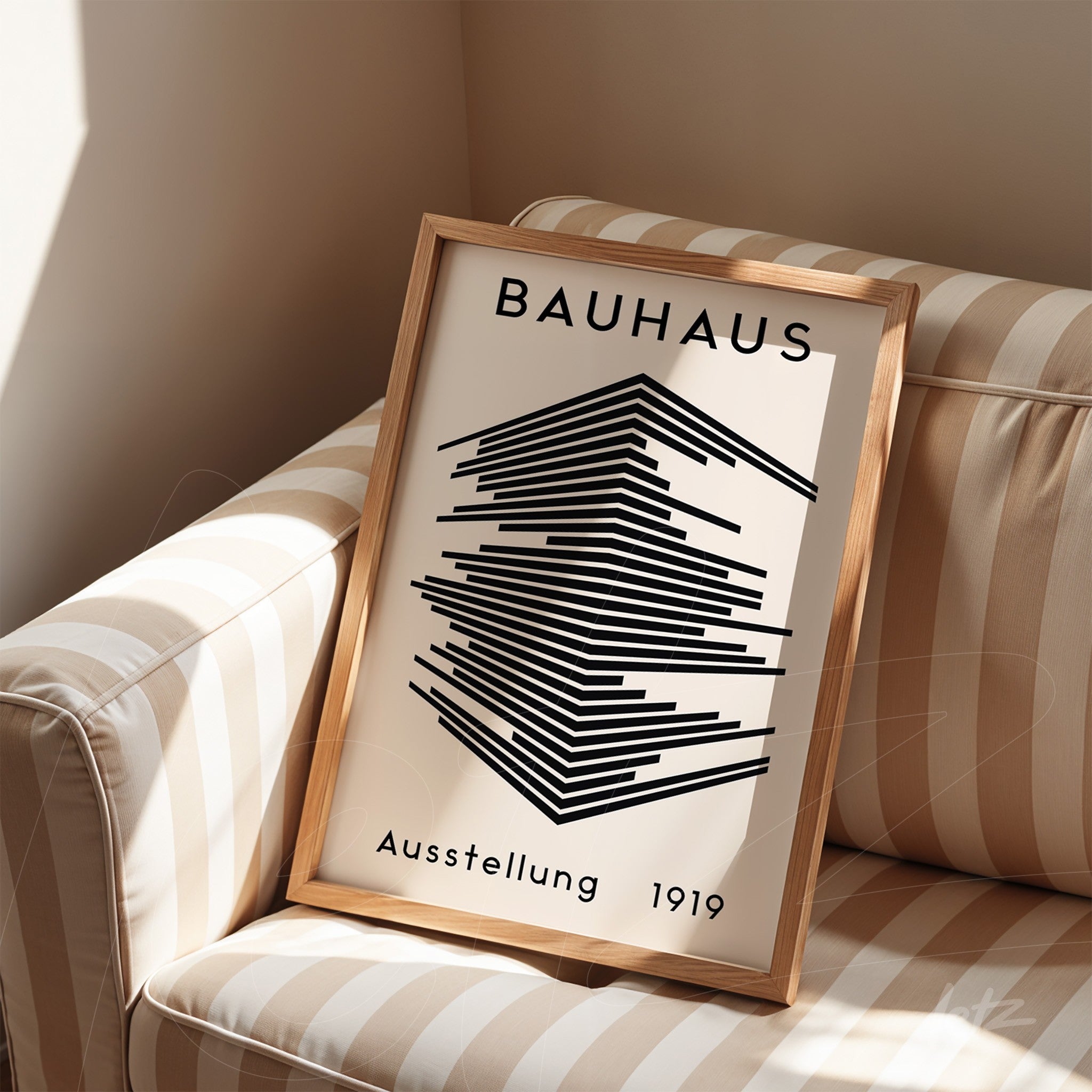 framed Bauhaus 1919 print displayed on striped couch with light wood frame