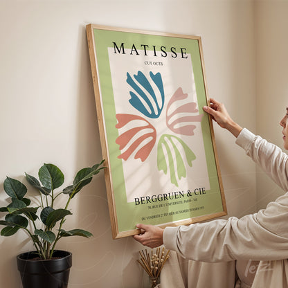 framed wall art featuring modern abstract design with colorful shapes on green background and light wood frame