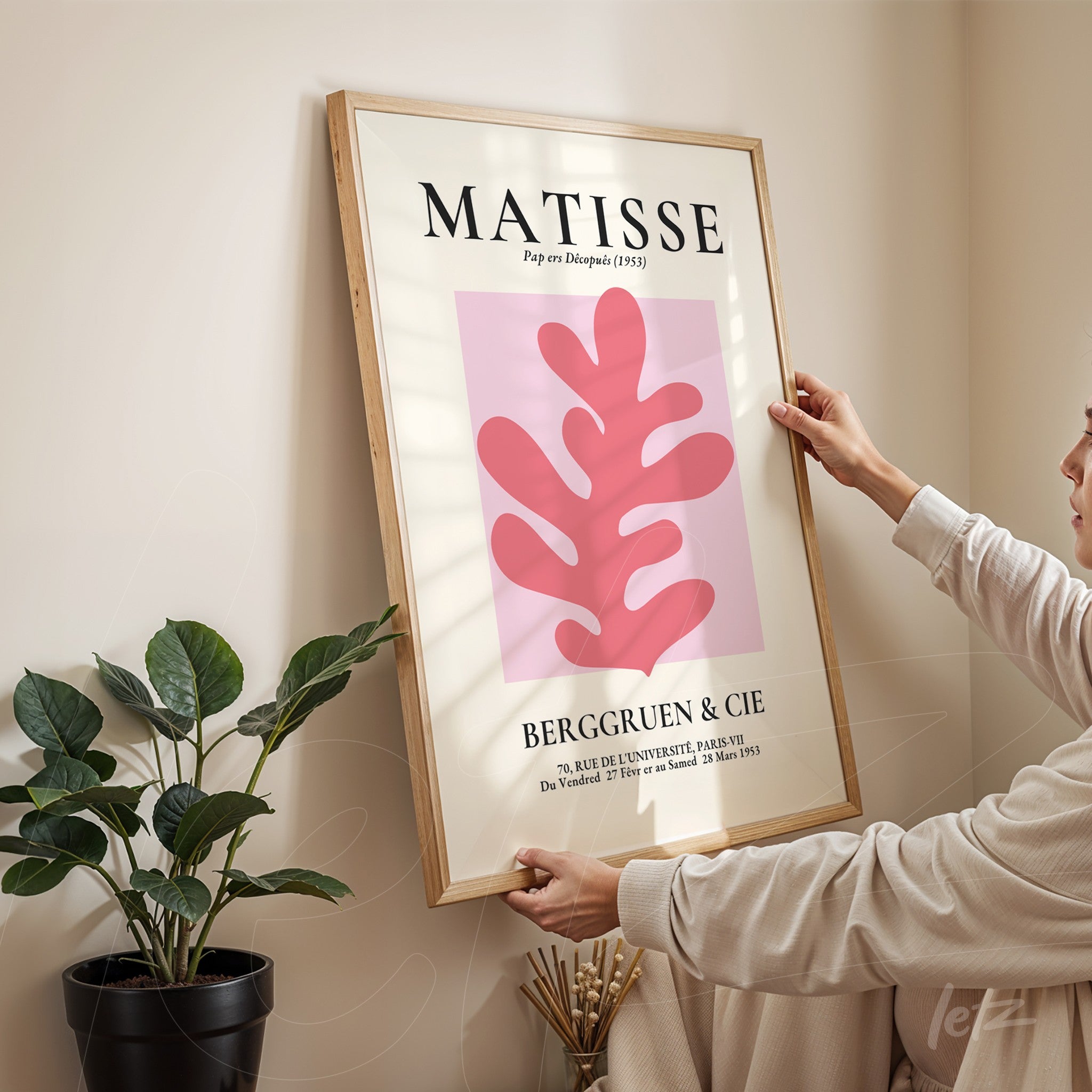 framed wall art featuring modern Matisse-inspired design with organic shapes in shades of pink and a neutral background held by a person next to a plant