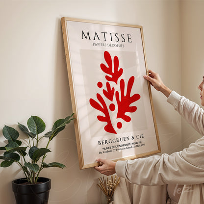 framed wall art featuring matisse design with organic red shapes on white background and light wood frame