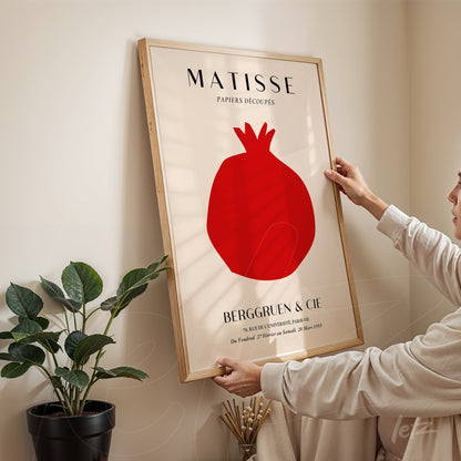 framed artwork inspired by Matisse featuring a red pomegranate with a light wood frame