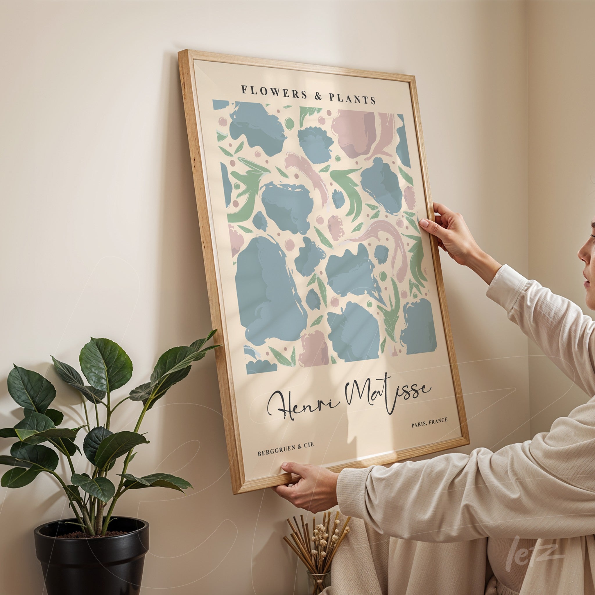 decorative wall art featuring abstract floral design in pastel colors, light wood frame, mounted on the wall with a woman prominently holding the artwork