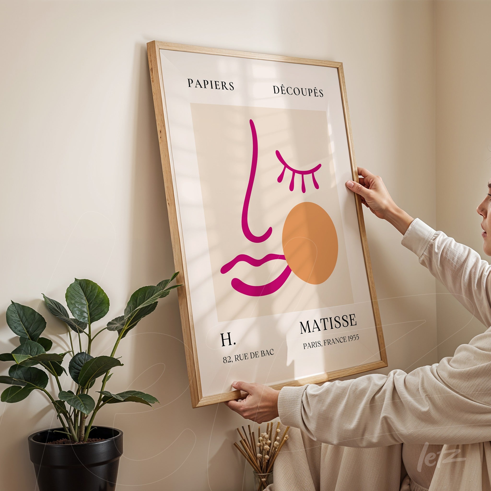 framed artwork featuring an abstract face illustration with colorful lines in a light wood frame