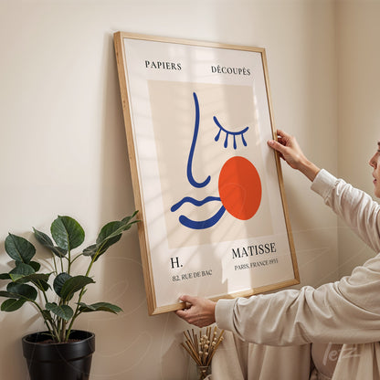 framed wall art with modern face illustration featuring primary colors, displayed against a light neutral wall